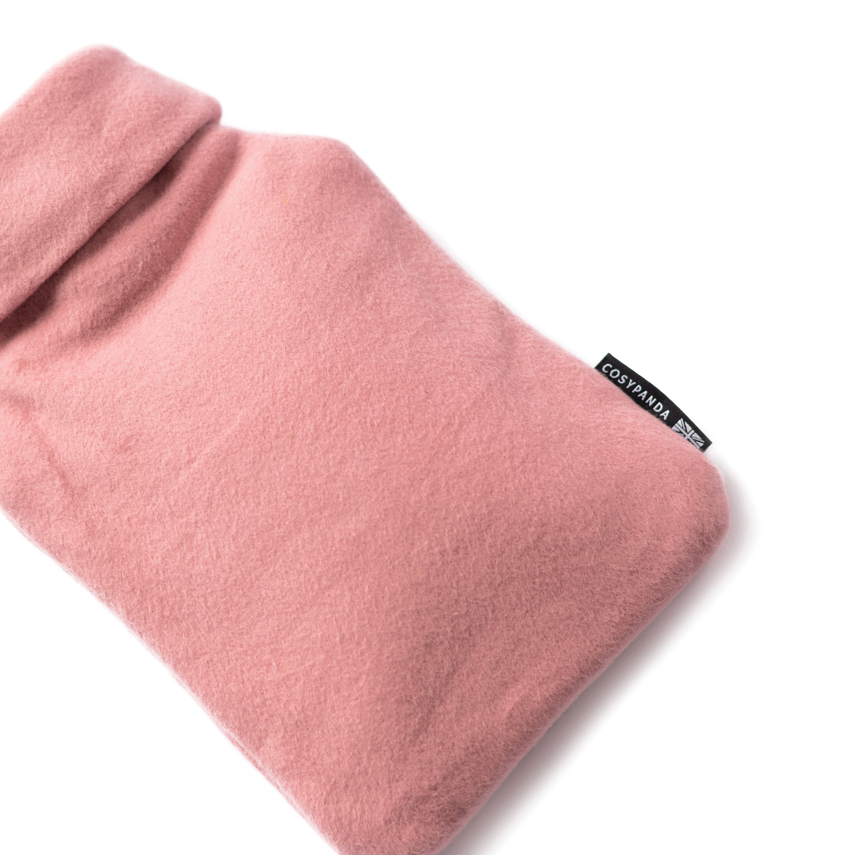A cozy pink organic cotton hot water bottle with a roll-neck design, handmade in the UK, perfect for warmth and comfort.