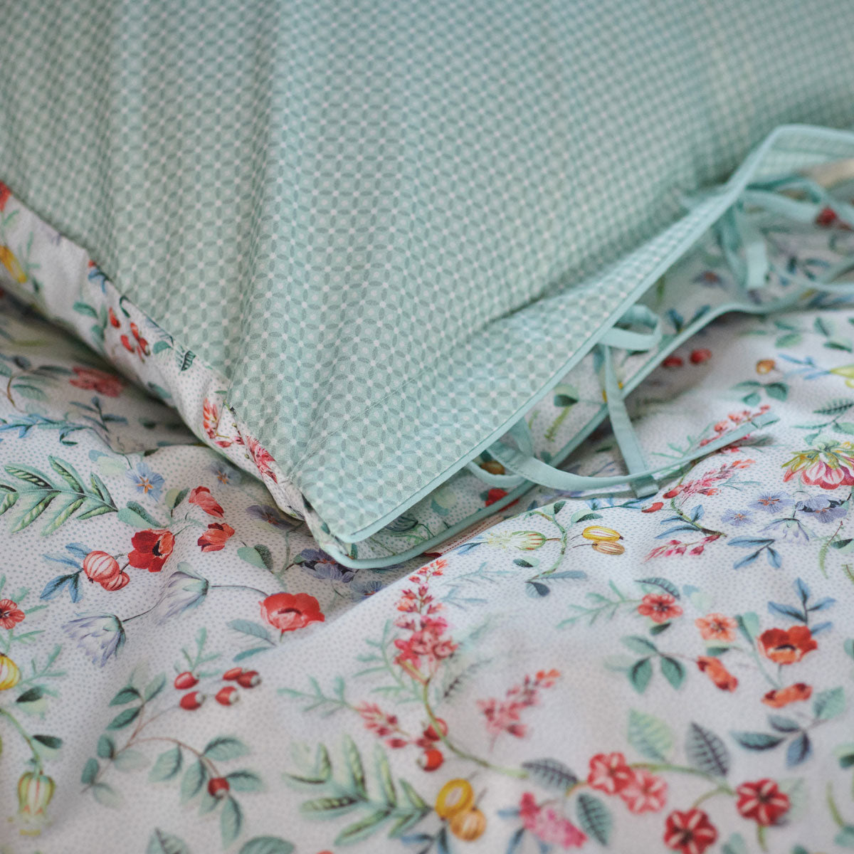 PIP Studio Midnight Garden White Cotton Quilt Cover Set featuring floral print and light blue trim, displayed on a bed.