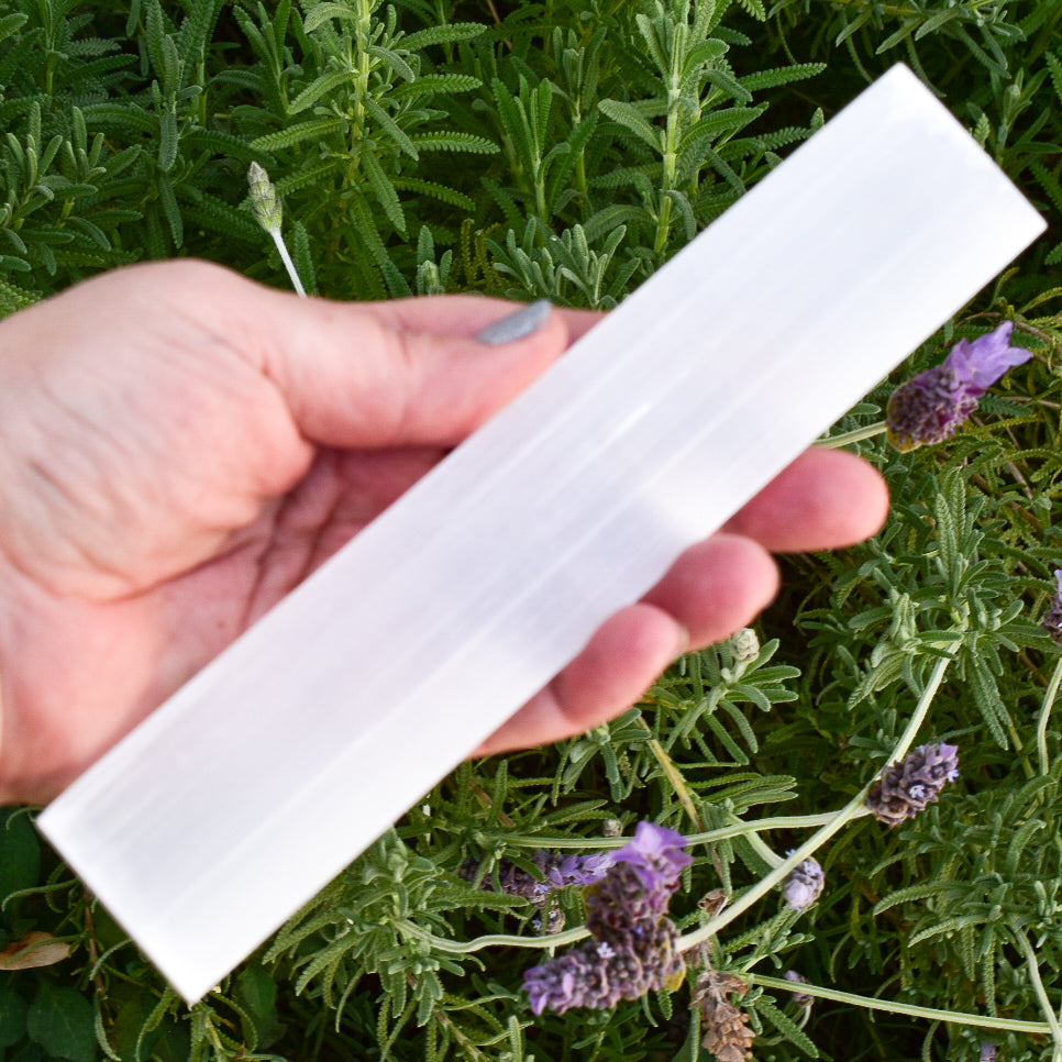 A polished Selenite bar measuring 8 inches, ideal for cleansing and charging crystals, with a smooth, reflective surface.