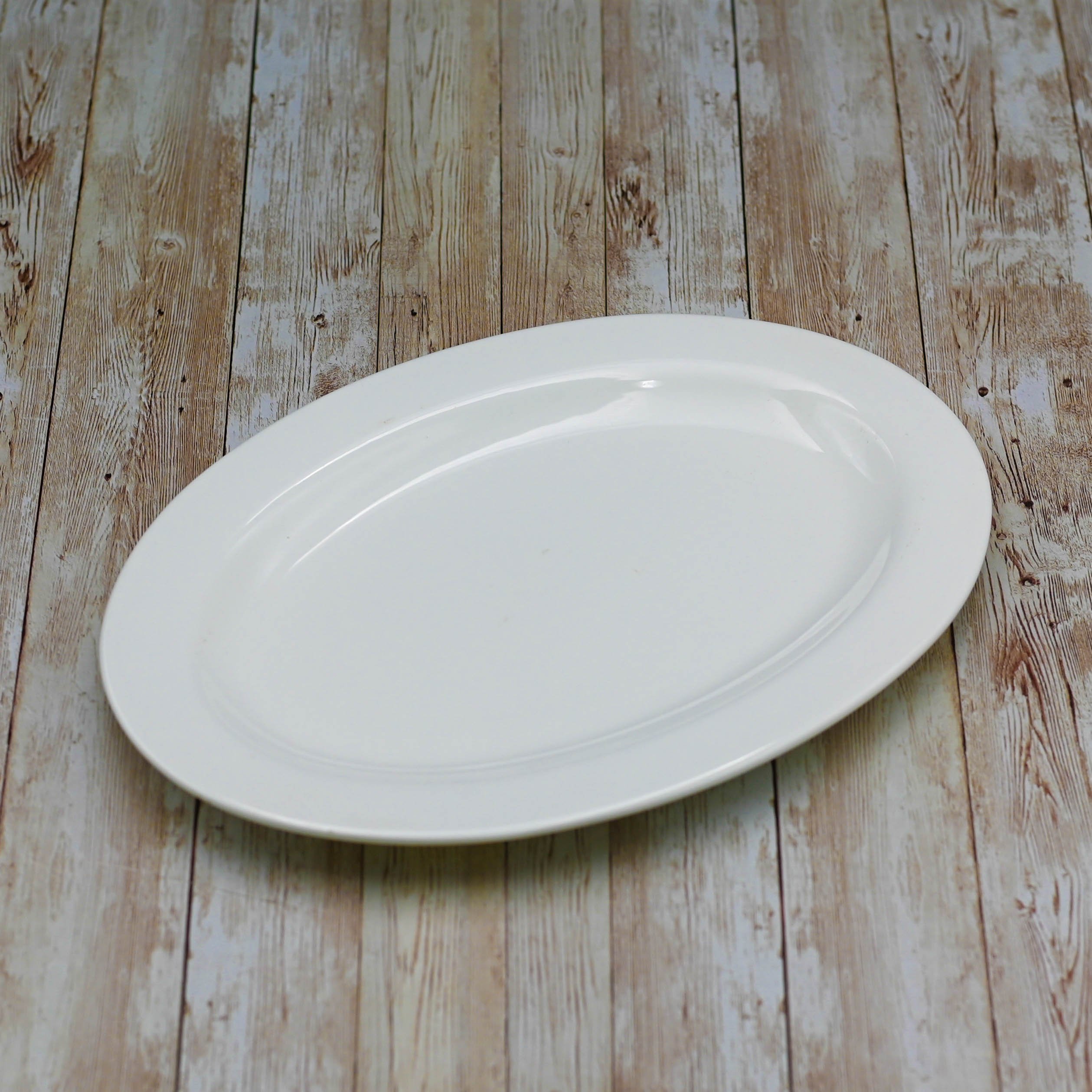 A 14-inch white oval platter with a rolled rim, made of fine porcelain, ideal for elegant dining presentations.