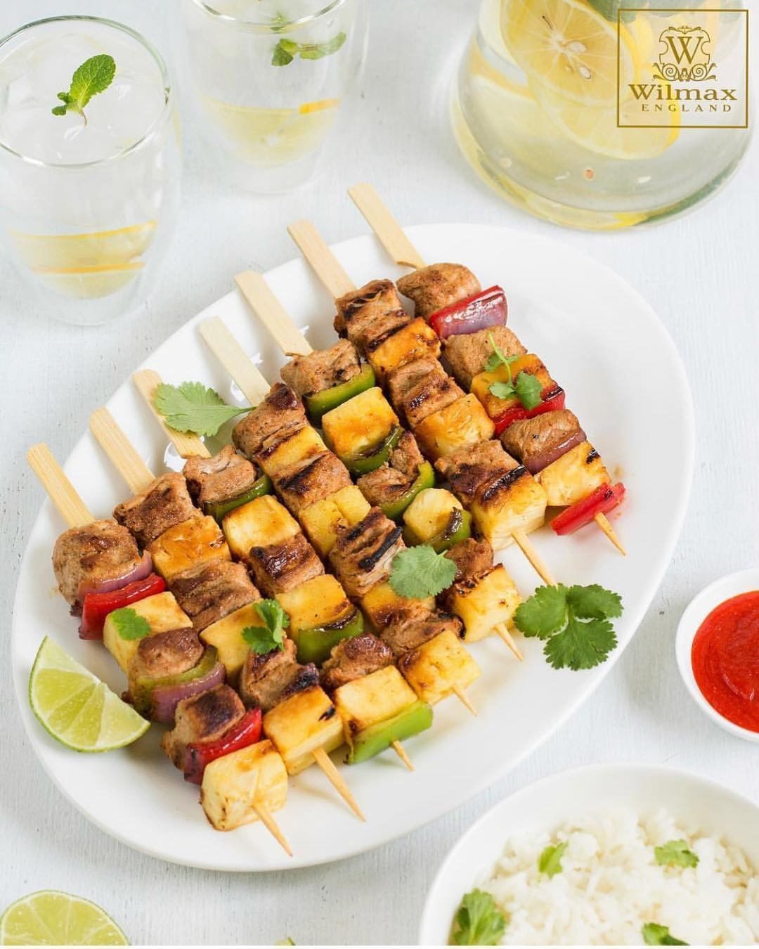 A 14-inch white oval platter with a rolled rim, made of fine porcelain, ideal for elegant dining presentations.