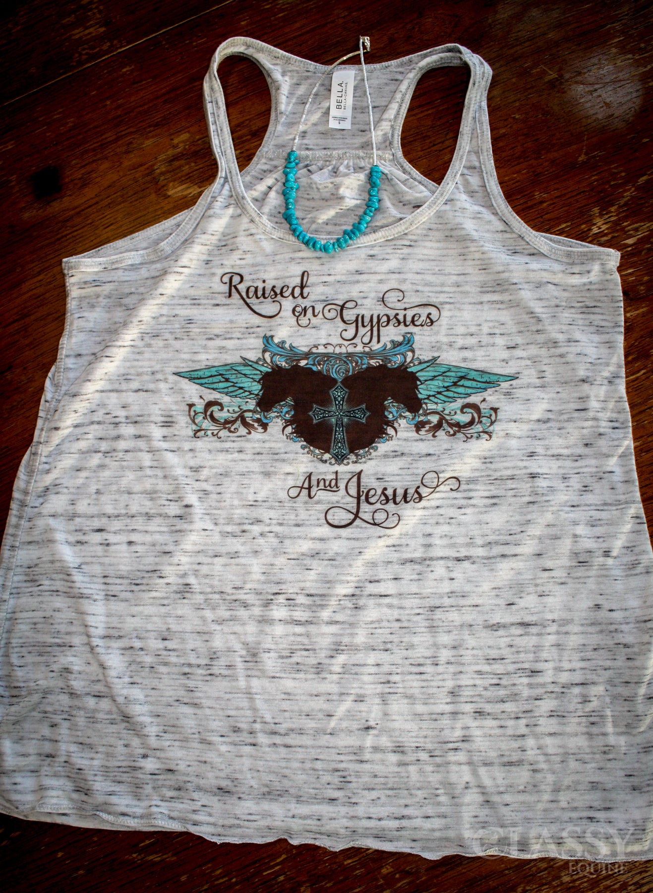 A stylish flowy tank top featuring the phrase 'Raised on Gypsies and Jesus', designed for comfort and casual wear.