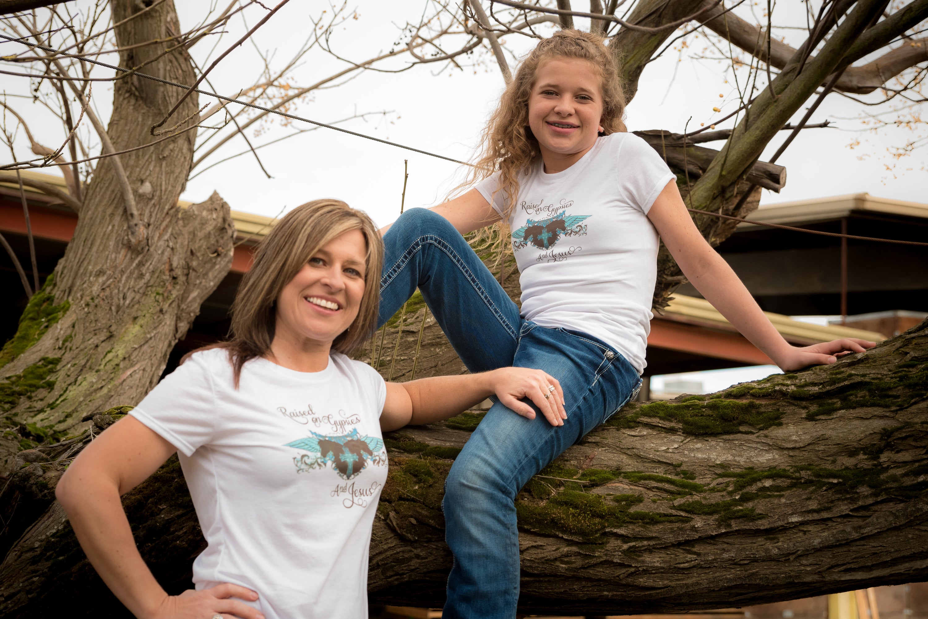 A stylish women's T-shirt featuring the phrase 'Raised on Gypsies and Jesus' in a unique design, available in various sizes.