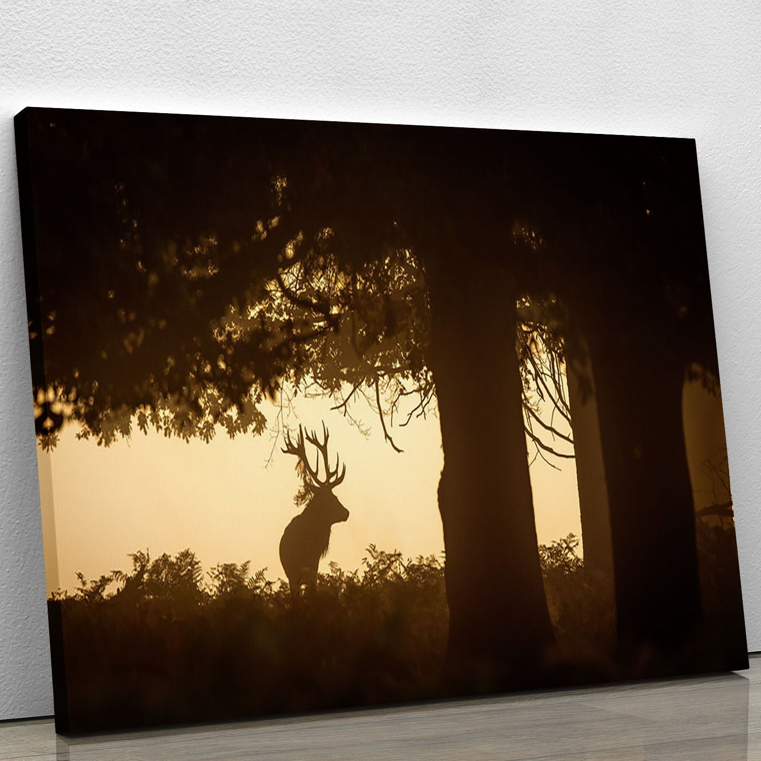 A beautiful canvas print featuring a red deer stag silhouette in a serene forest setting, showcasing nature's elegance.
