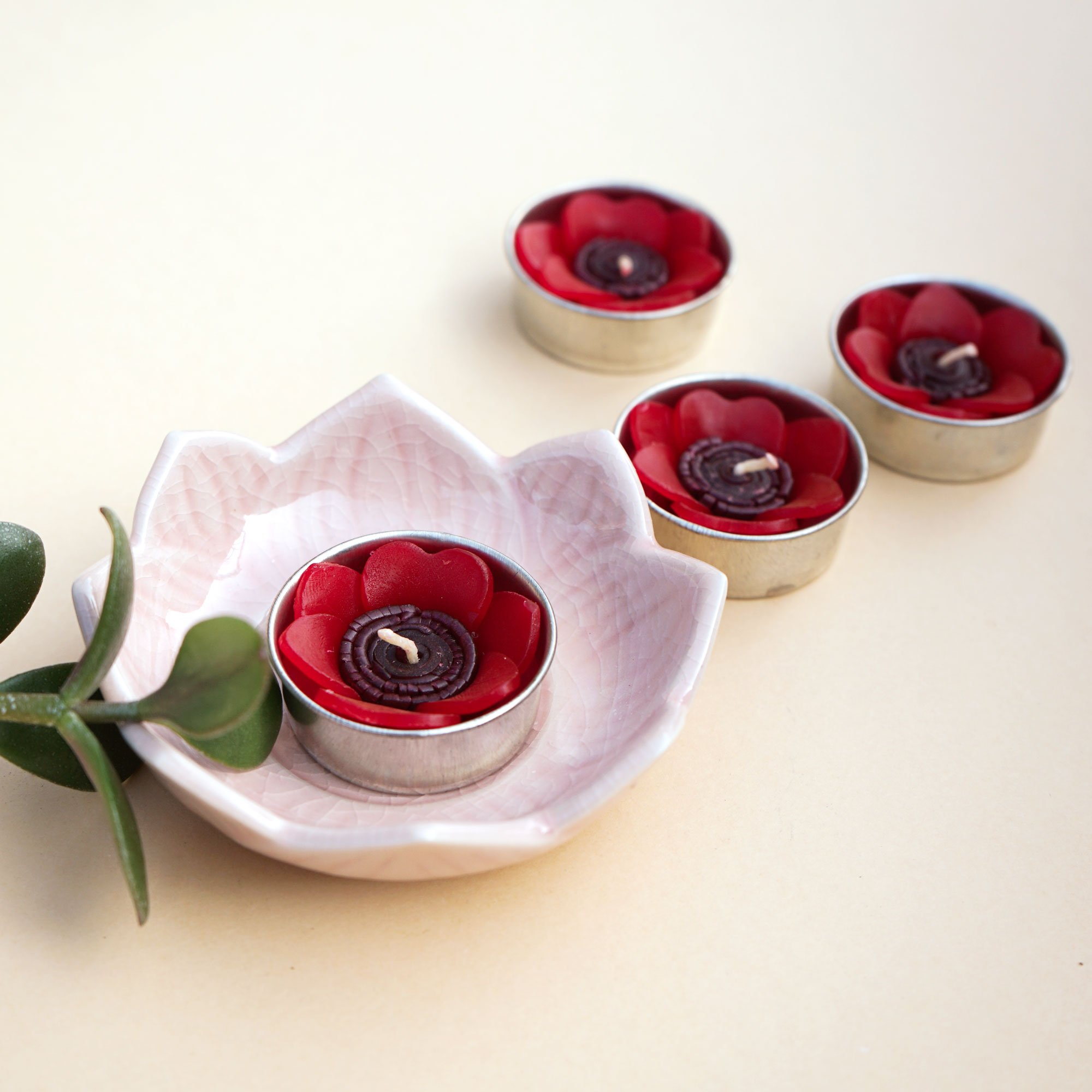 A set of eight red poppy scented tealights in a decorative box, showcasing their vibrant color and floral design.