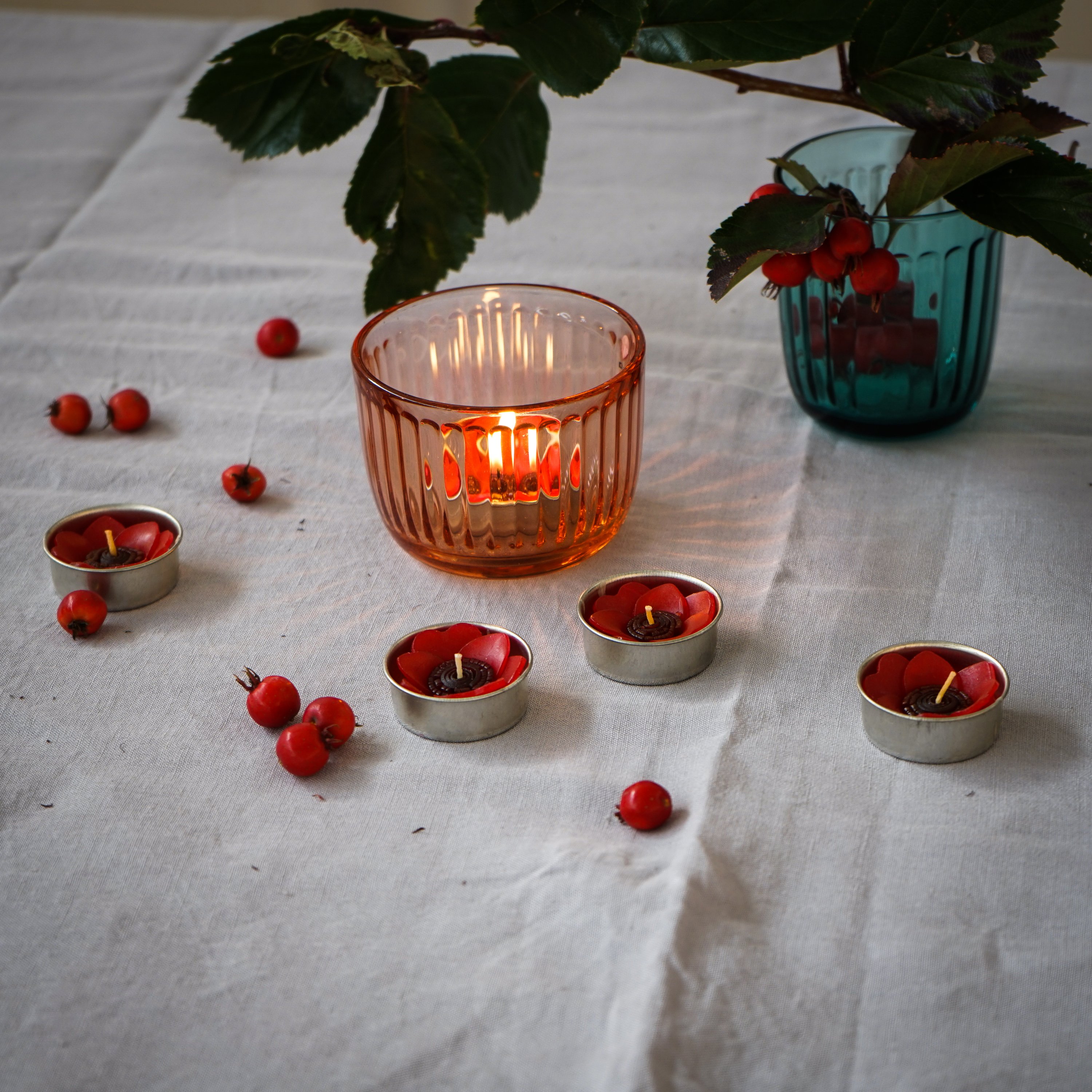 A set of eight red poppy scented tealights in a decorative box, showcasing their vibrant color and floral design.