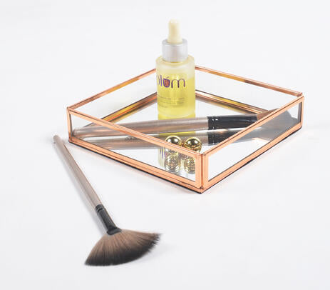 Rose-gold stainless steel and glass vanity tray, showcasing elegant design and craftsmanship.