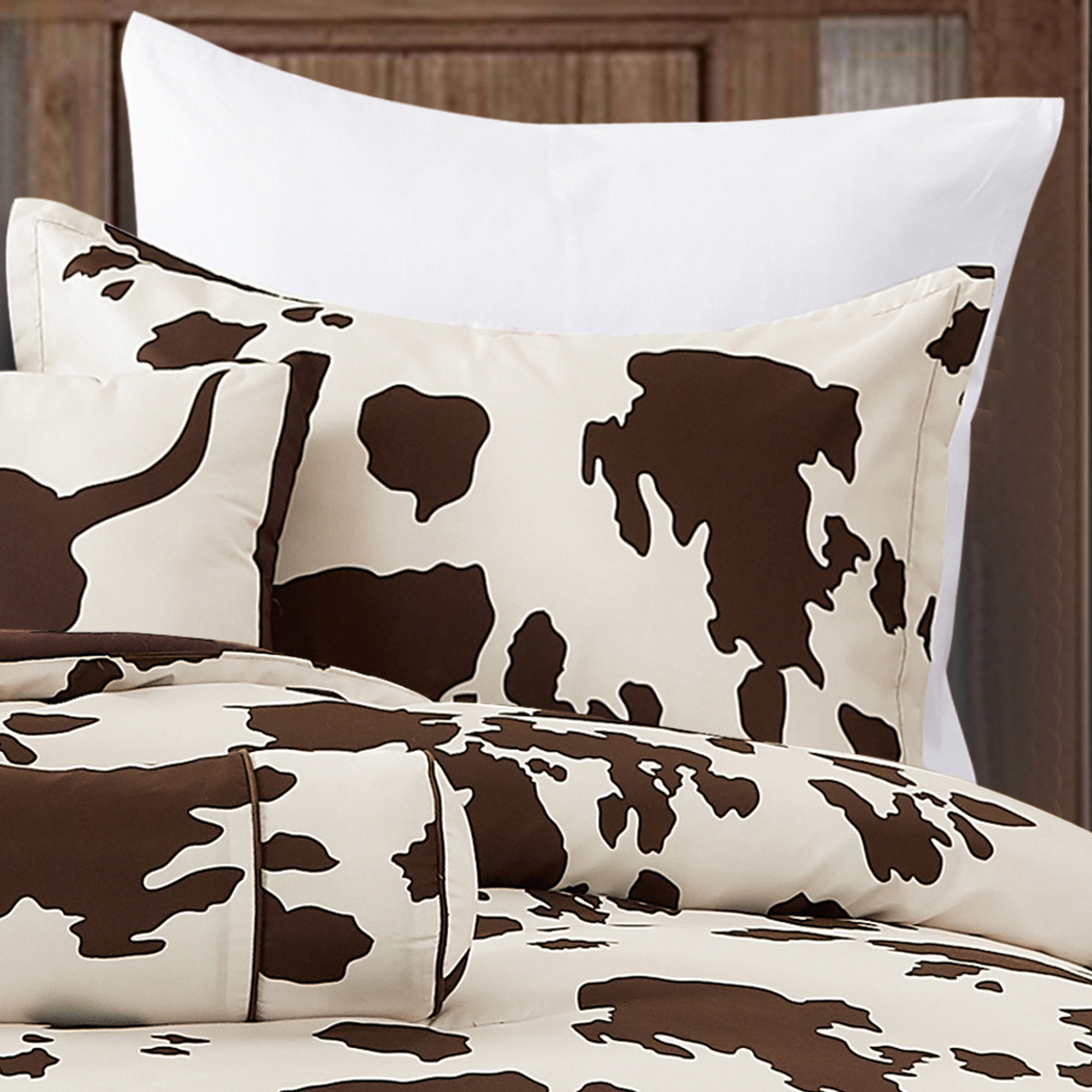 Rustic Cowhide Brown Cow Skull Comforter Set displayed on a bed, featuring a luxurious design with matching pillows and bed skirt.
