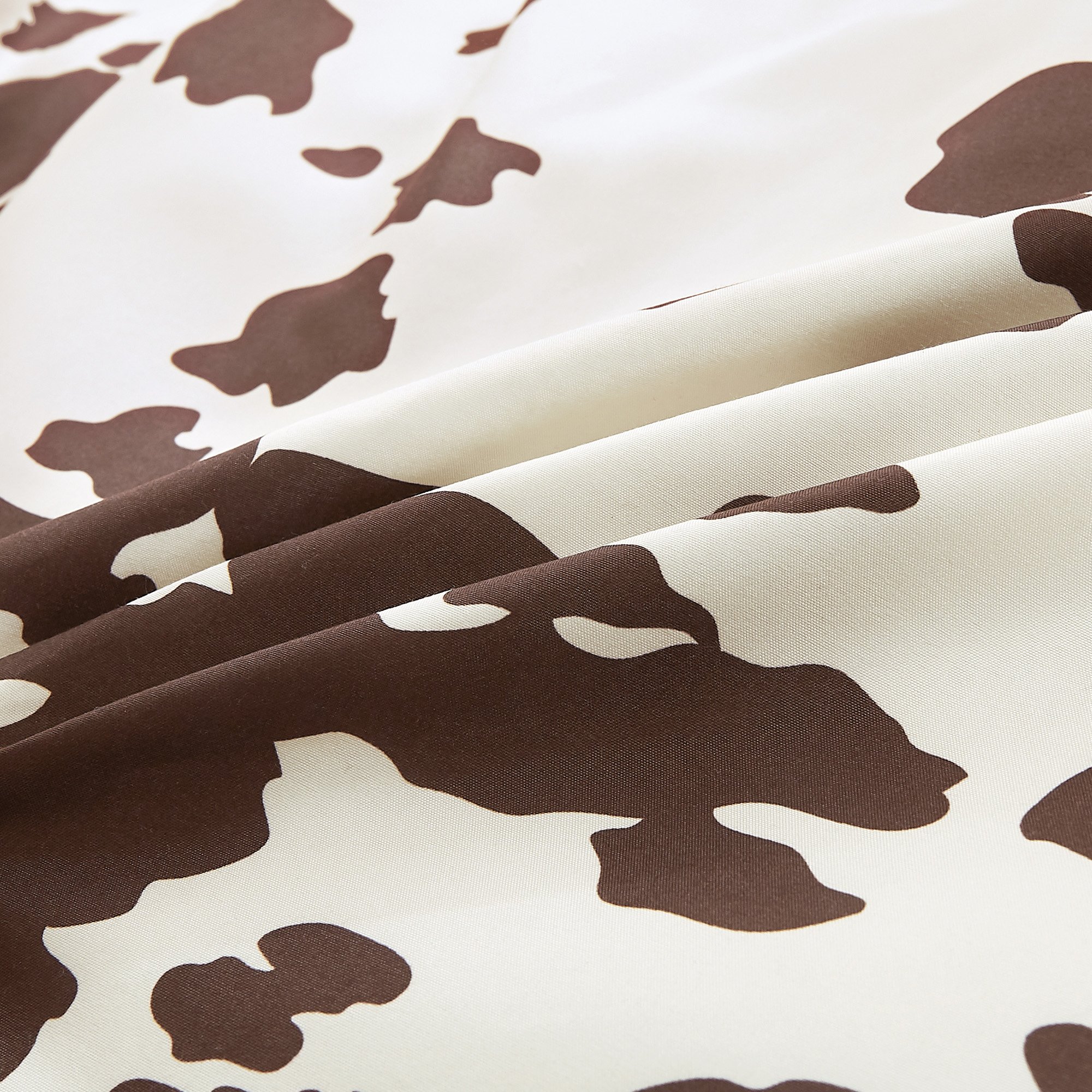Rustic Cowhide Brown Cow Skull Comforter Set displayed on a bed, featuring a luxurious design with matching pillows and bed skirt.