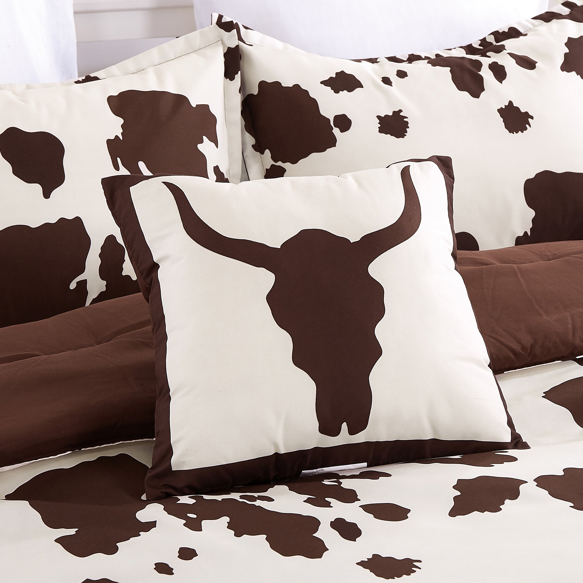 Rustic Cowhide Brown Cow Skull Comforter Set displayed on a bed, featuring a luxurious design with matching pillows and bed skirt.