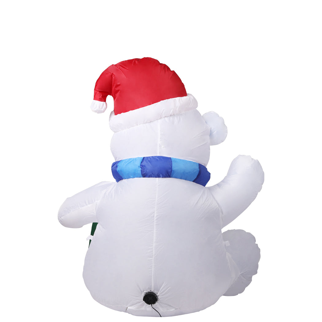 A 1.2M inflatable Christmas polar bear with LED lights, standing in a festive yard, showcasing its cheerful design and bright illumination.