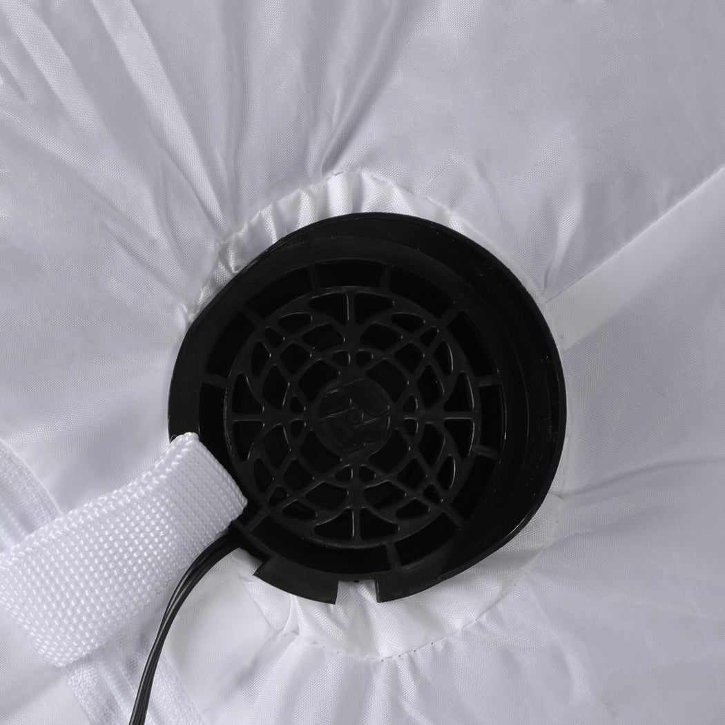 A 1.2M inflatable Christmas polar bear with LED lights, standing in a festive yard, showcasing its cheerful design and bright illumination.