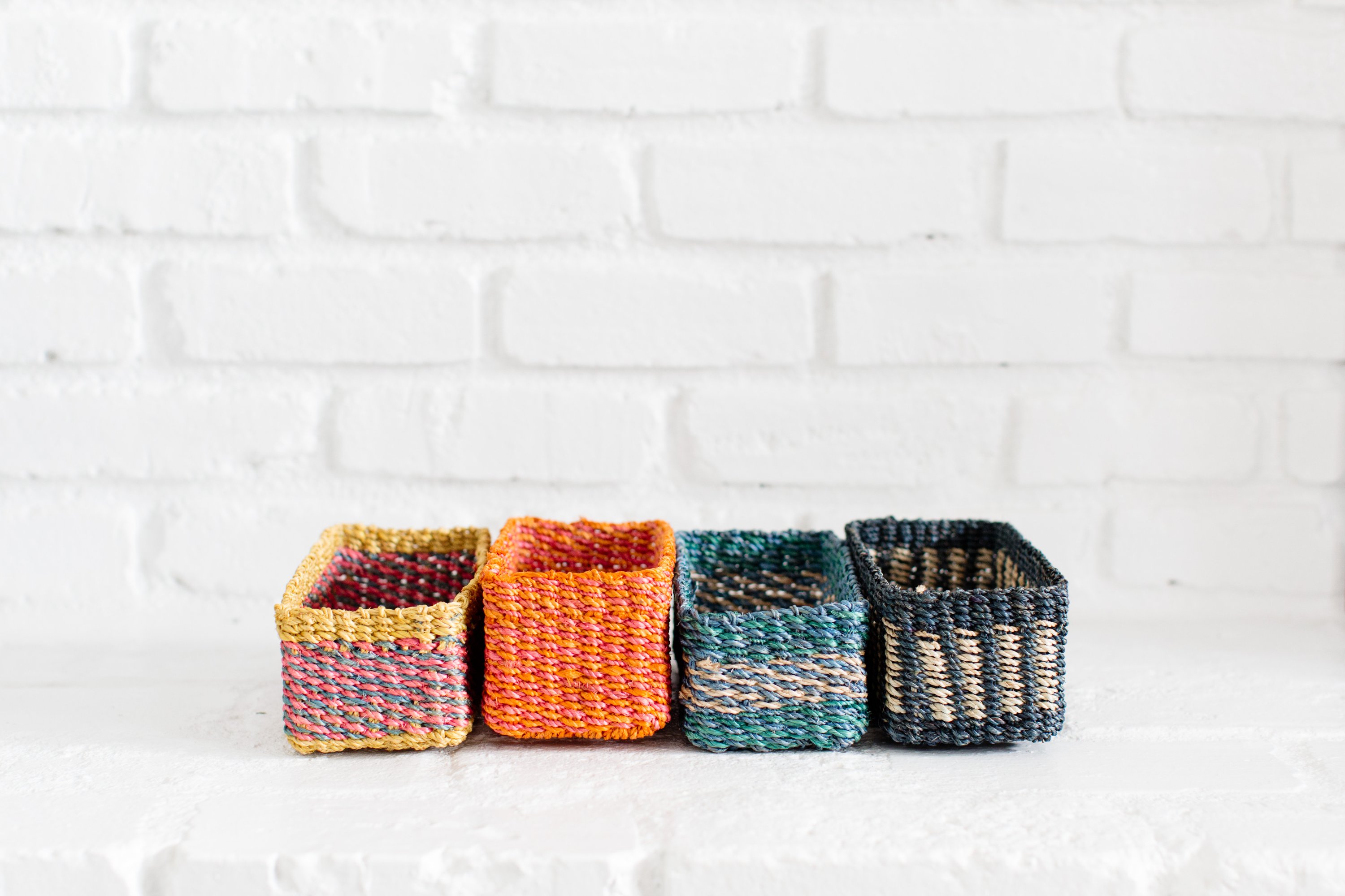 Handwoven seagrass storage tray with black and white band, perfect for organizing small items.