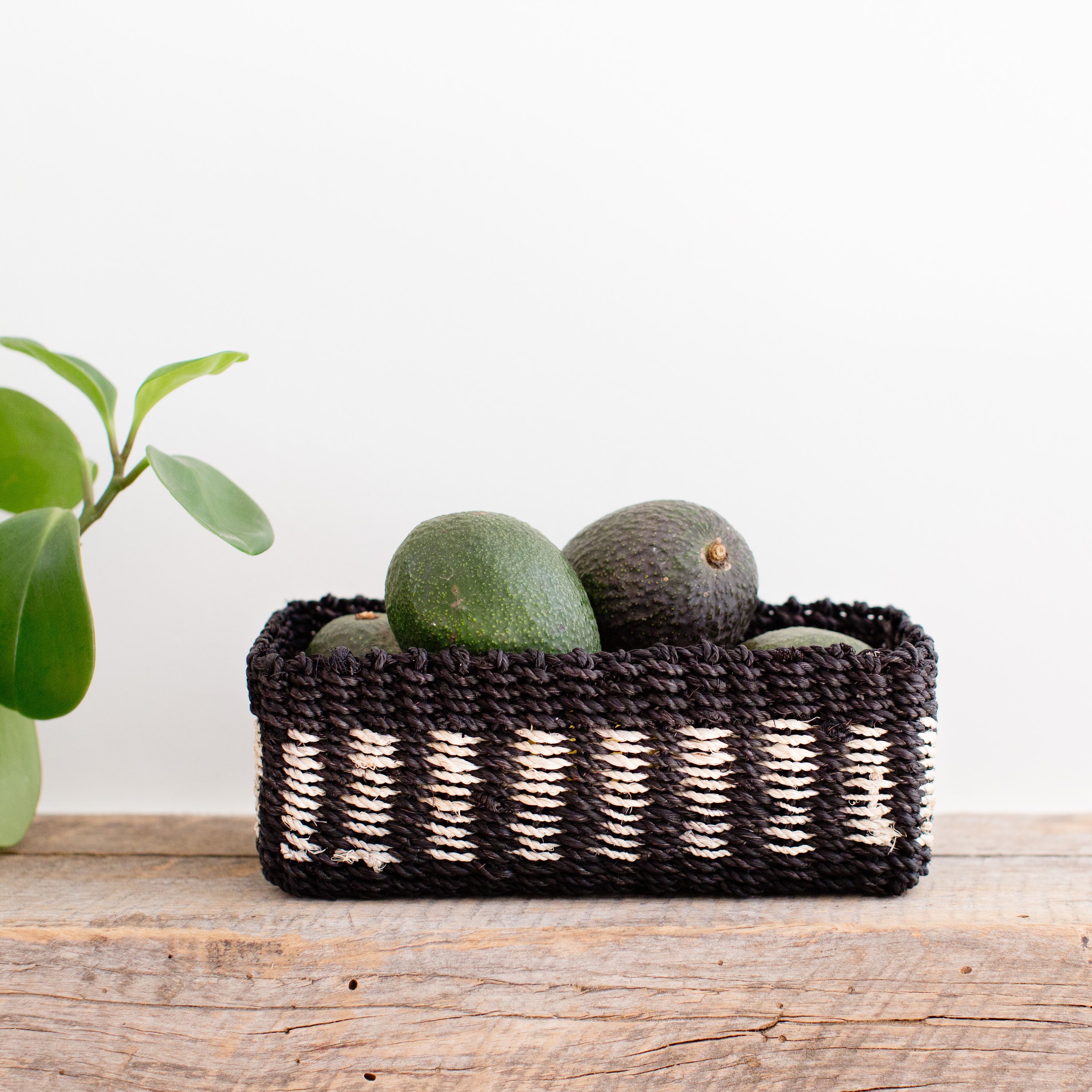 Handwoven seagrass storage tray with black and white band, perfect for organizing small items.