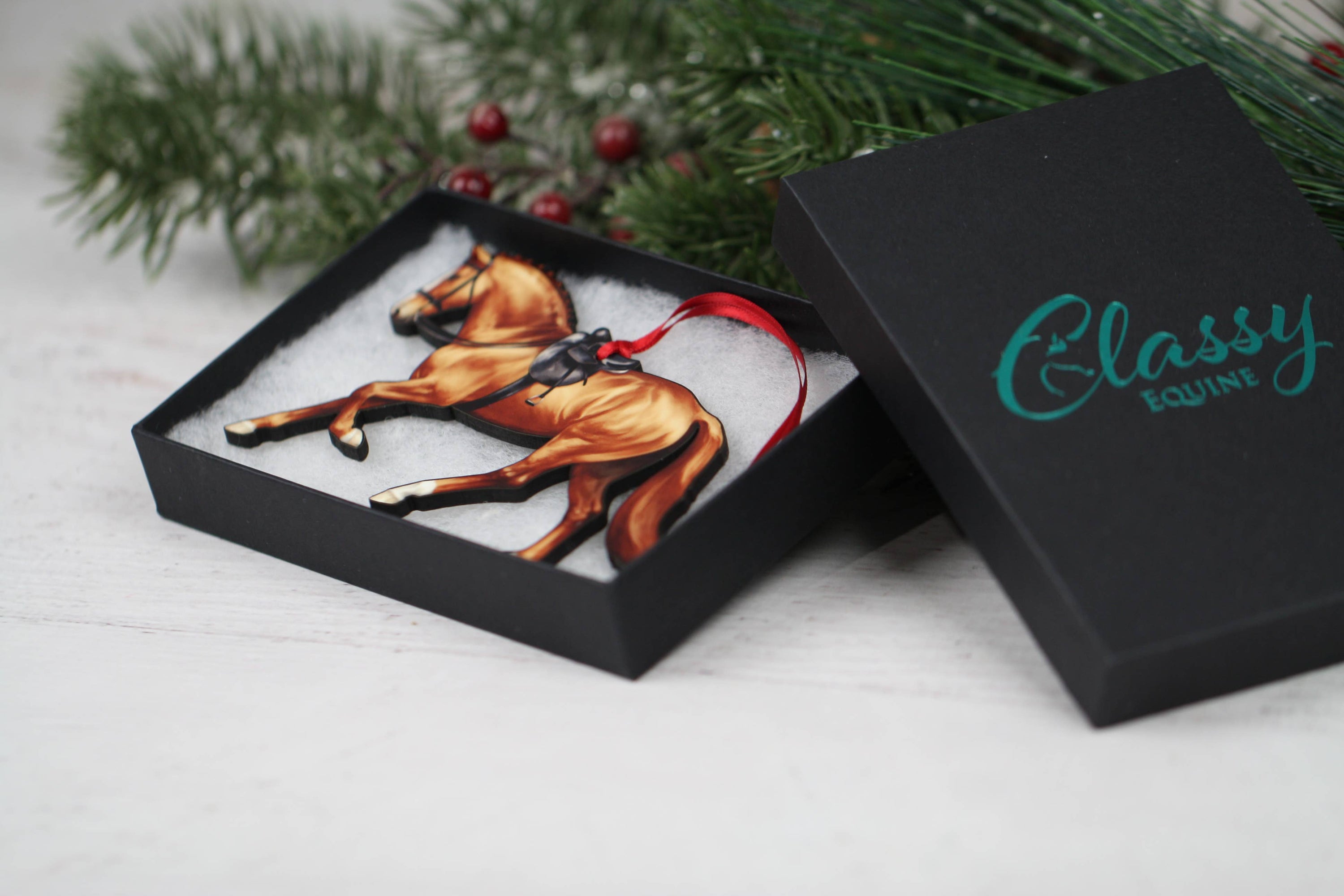 A beautifully crafted Side Saddle Horse Ornament in chestnut color, made from composite wood with a glossy finish, perfect for Christmas decoration.