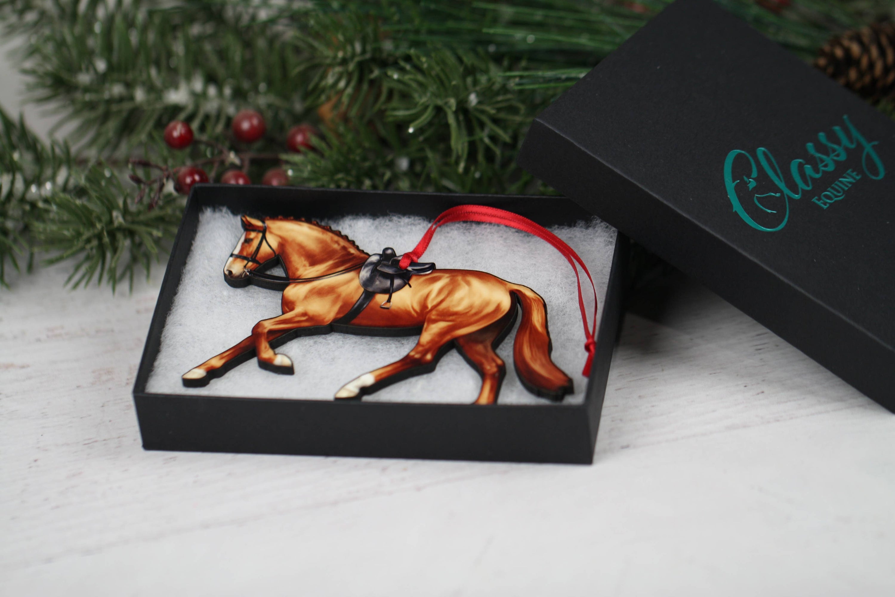 A beautifully crafted Side Saddle Horse Ornament in chestnut color, made from composite wood with a glossy finish, perfect for Christmas decoration.
