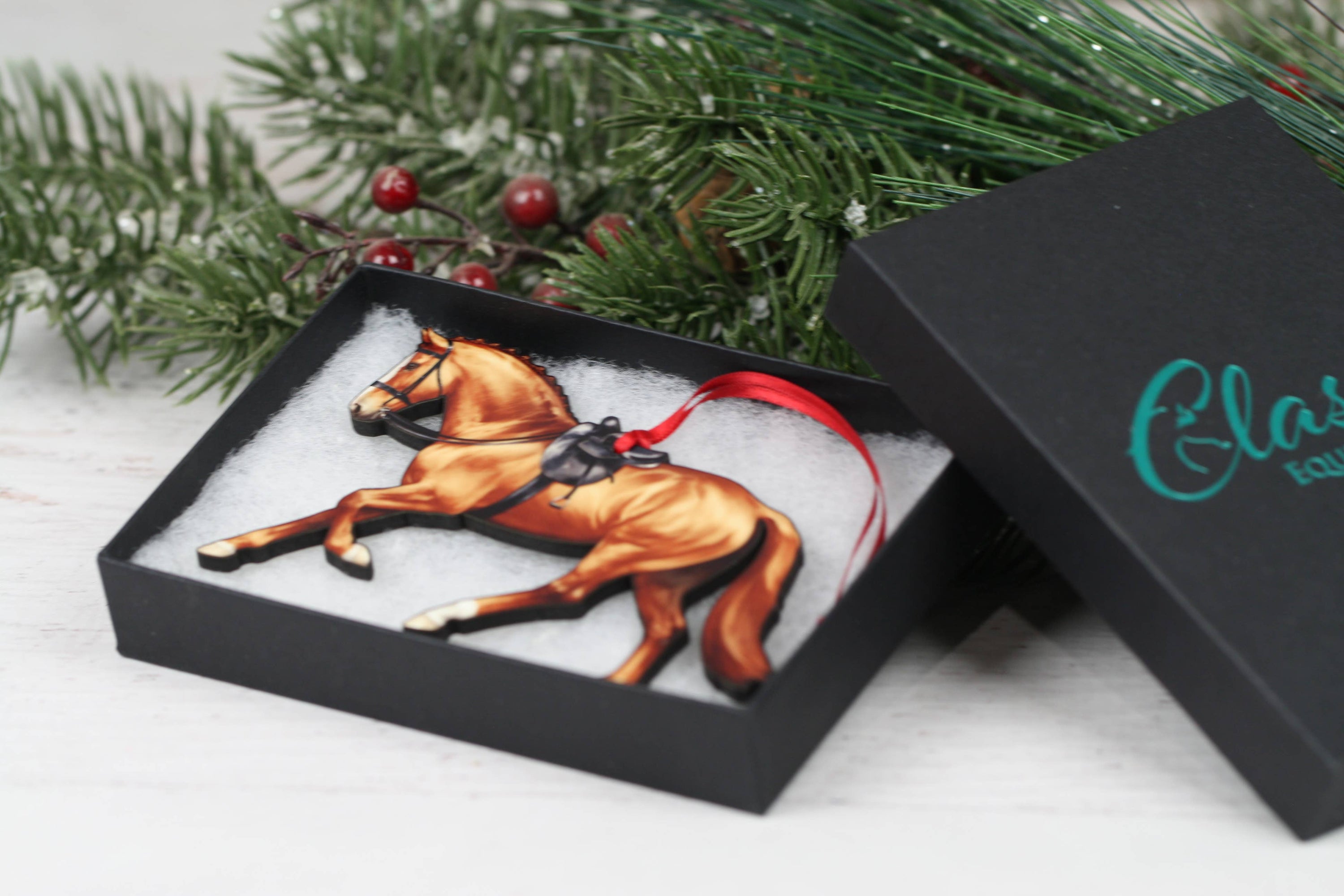 A beautifully crafted Side Saddle Horse Ornament in chestnut color, made from composite wood with a glossy finish, perfect for Christmas decoration.