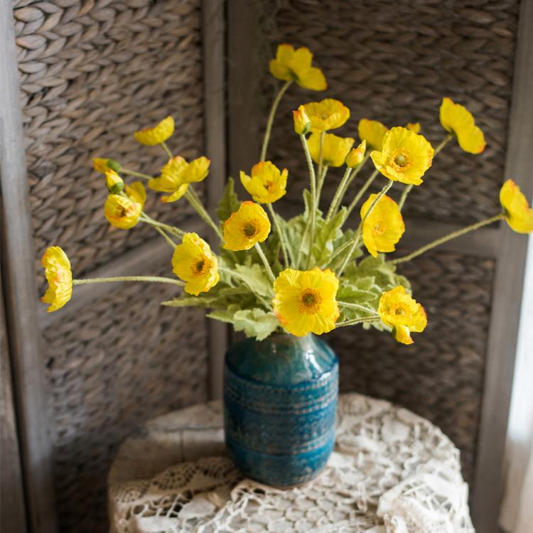 A 22-inch tall Silk Common Poppy Flower Stem featuring vibrant orange, red, and yellow blooms with green leaves, perfect for home decor.