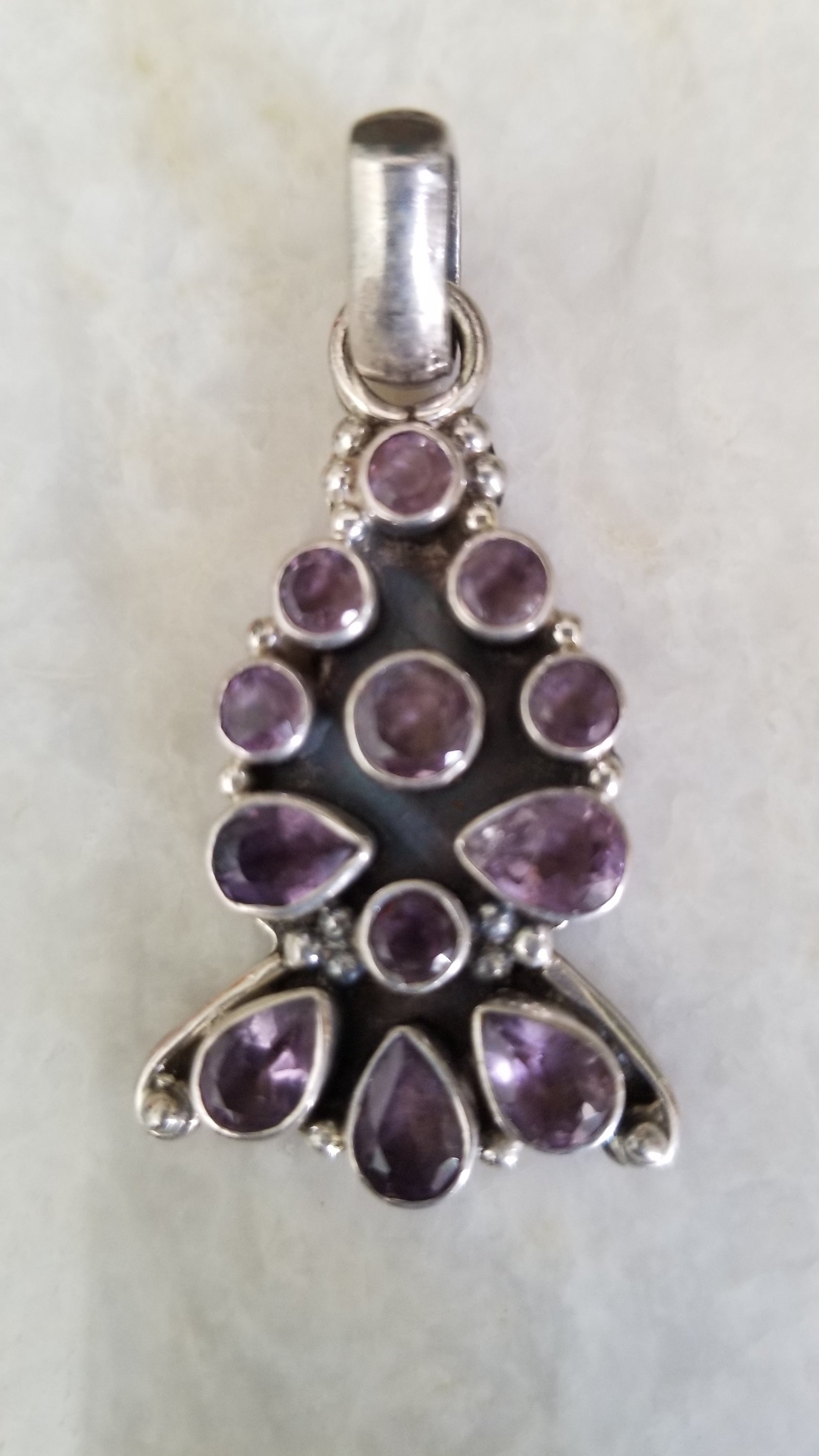 Handcrafted silver pendant featuring a vibrant semi-precious stone, showcasing intricate artisan details.
