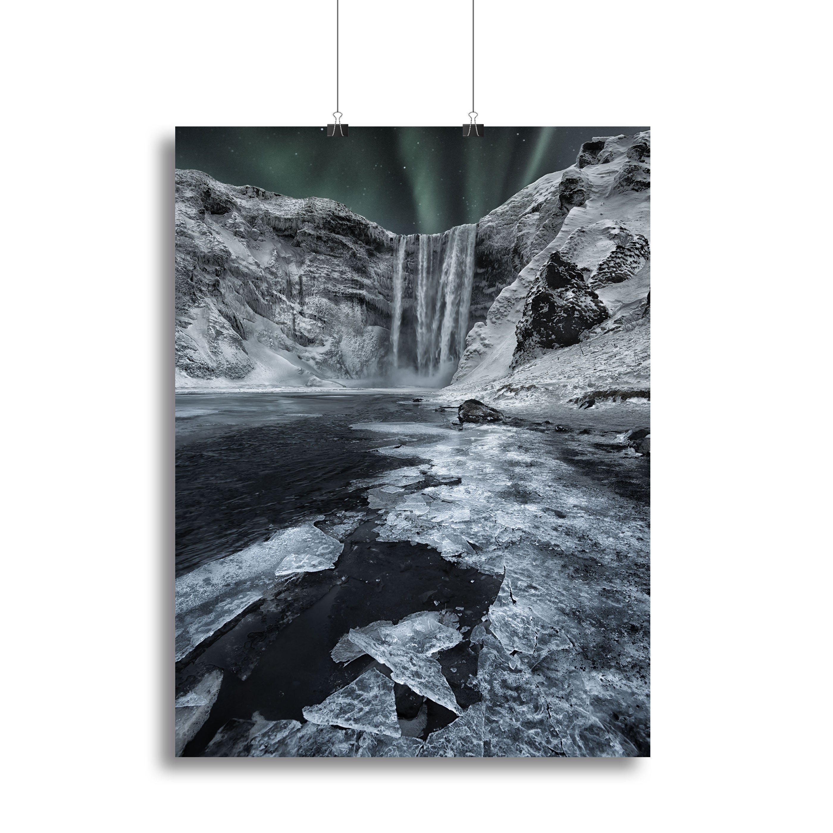 A beautiful canvas print of Skogafoss Falls, showcasing the majestic waterfall surrounded by lush greenery and a clear blue sky.