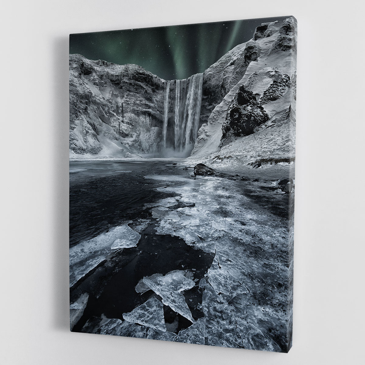 A beautiful canvas print of Skogafoss Falls, showcasing the majestic waterfall surrounded by lush greenery and a clear blue sky.