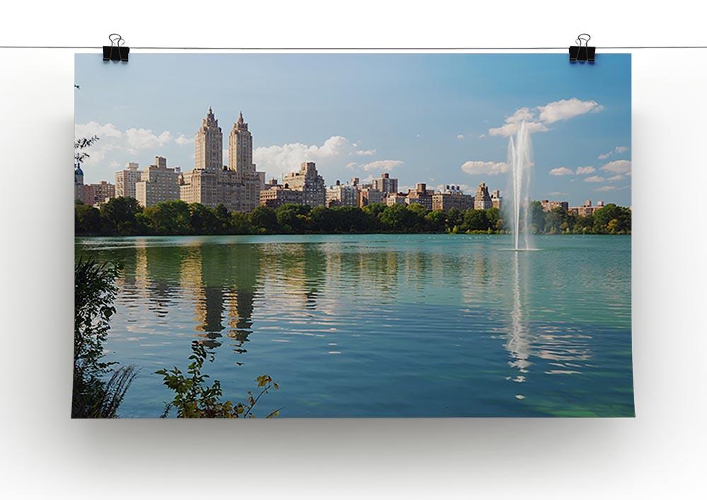 A beautiful canvas print depicting a skyline with skyscrapers and trees, reflecting on a tranquil lake, perfect for modern decor.