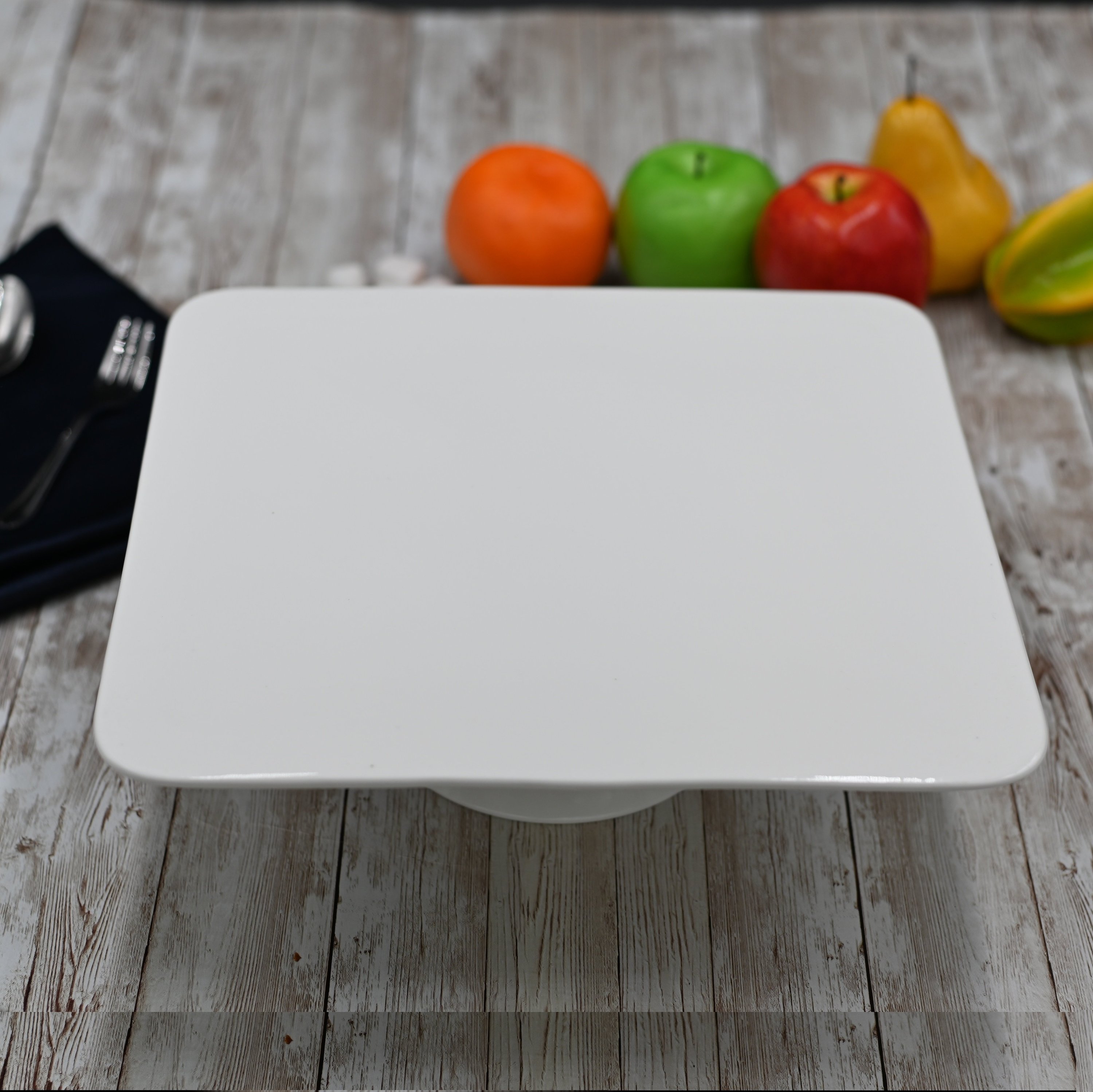 Elegant 12-inch square white porcelain cake stand, perfect for displaying cakes and desserts.