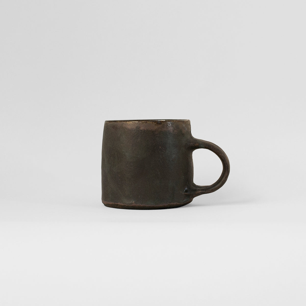Handmade TANG Ceramic Mug in Black Patina, showcasing unique design and artisanal craftsmanship by Gunvor Tangrand.