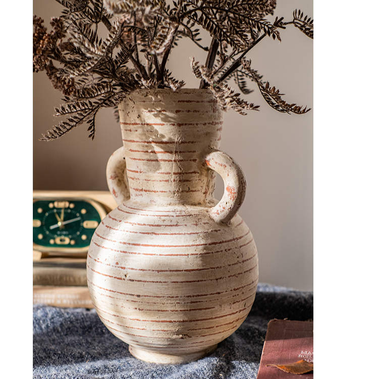 Handmade terracotta planter vase with handles, showcasing a rustic design and terracotta color with white accents.