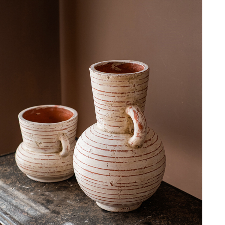 Handmade terracotta planter vase with handles, showcasing a rustic design and terracotta color with white accents.