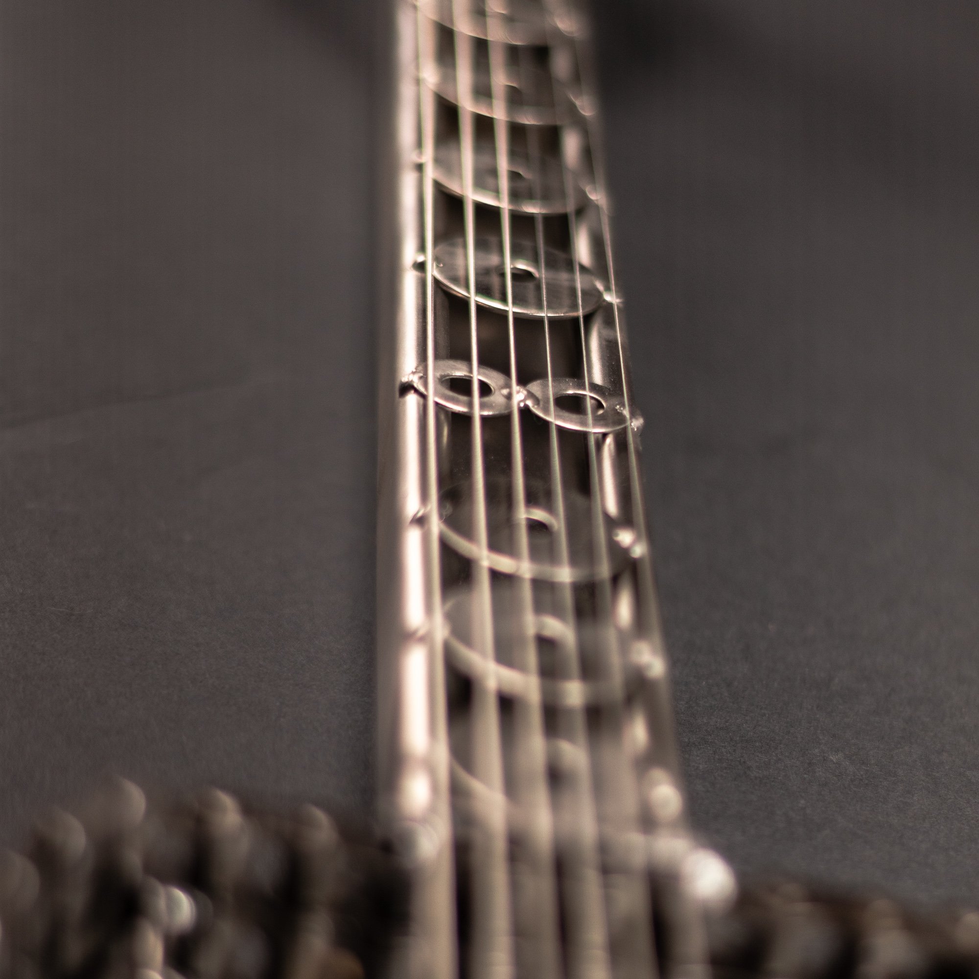 Handmade metal electric guitar sculpture, life-size, crafted from scrap metal with a clear finish.