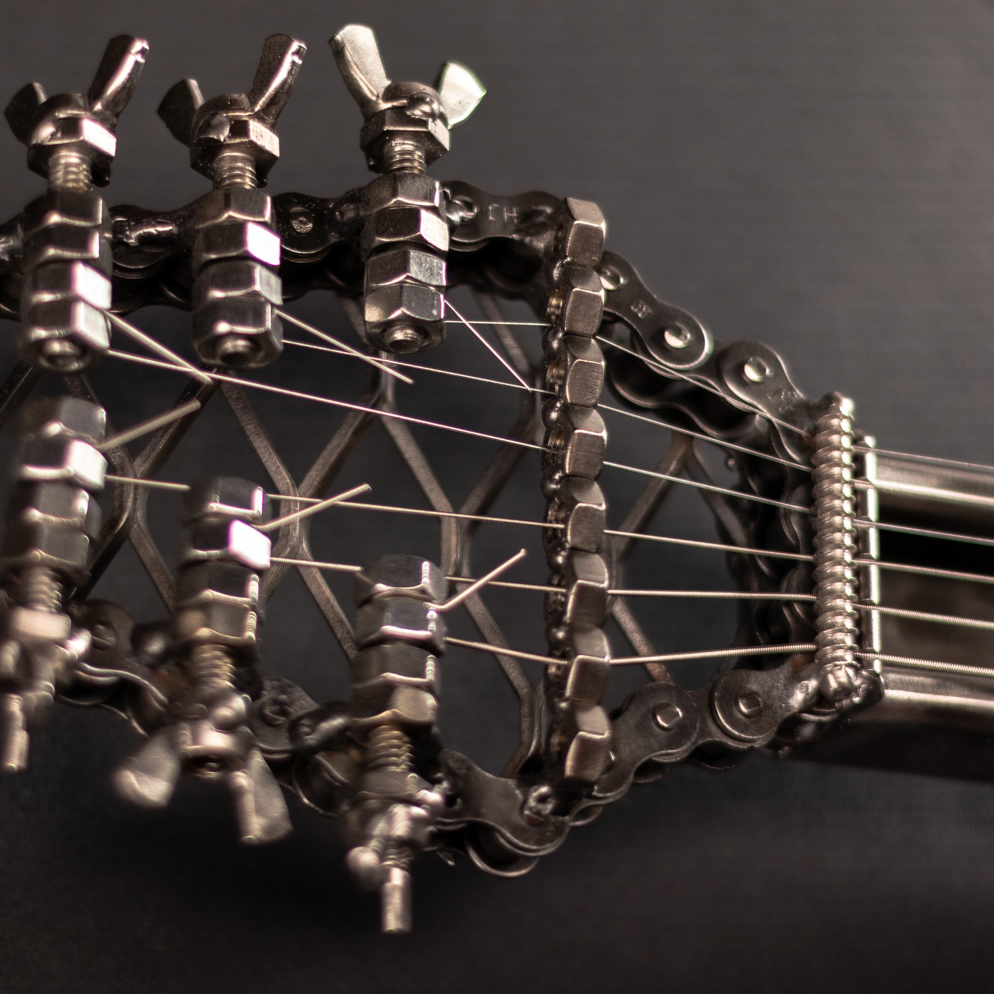 Handmade metal electric guitar sculpture, life-size, crafted from scrap metal with a clear finish.