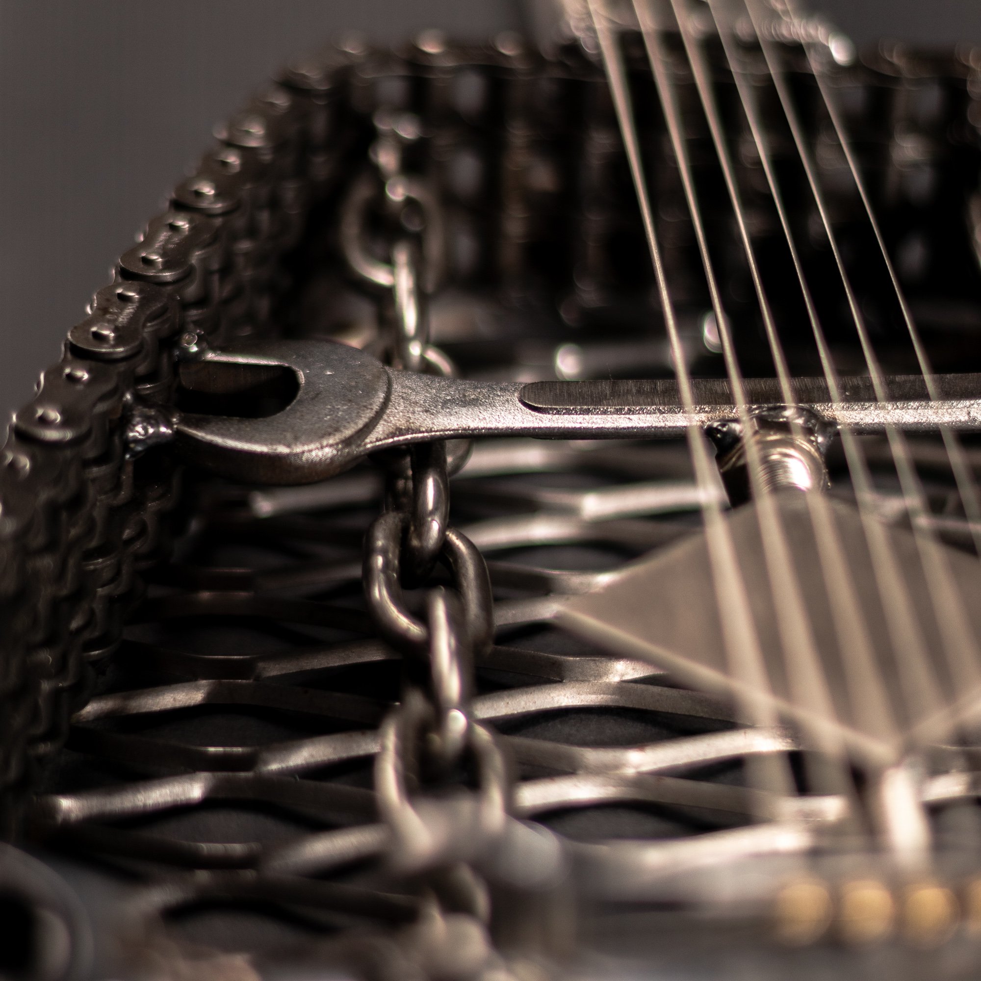 Handmade metal electric guitar sculpture, life-size, crafted from scrap metal with a clear finish.