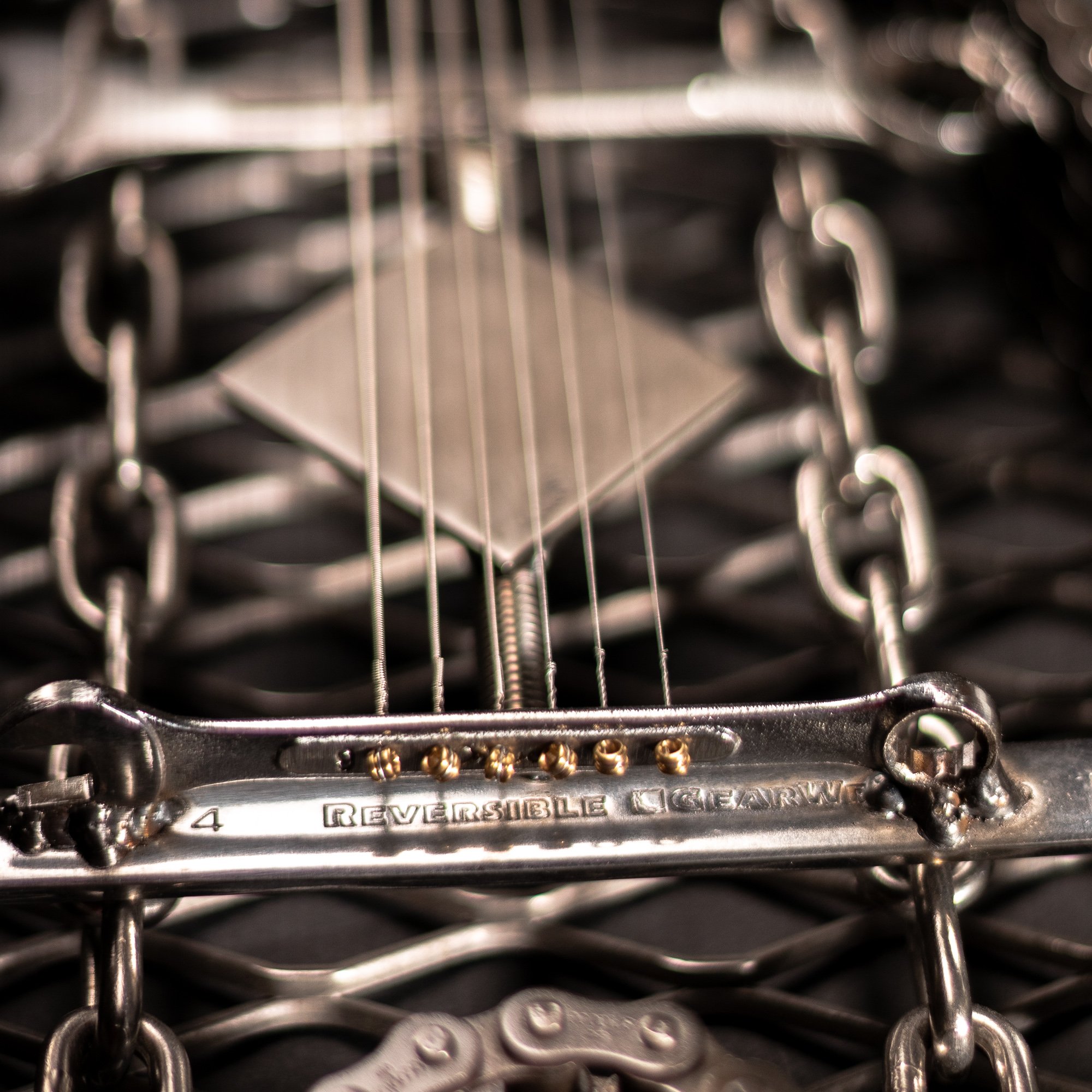 Handmade metal electric guitar sculpture, life-size, crafted from scrap metal with a clear finish.