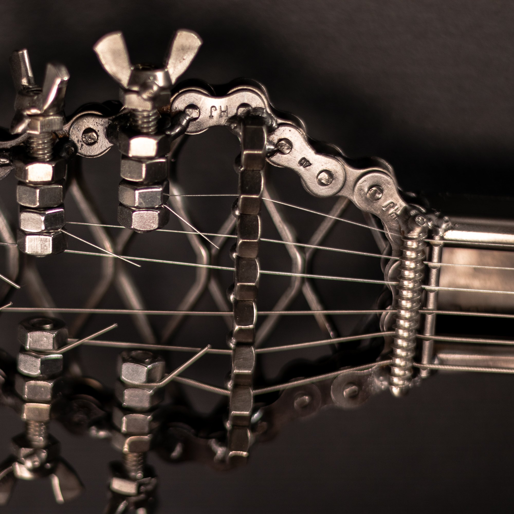 Handmade metal electric guitar sculpture, life-size, crafted from scrap metal with a clear finish.