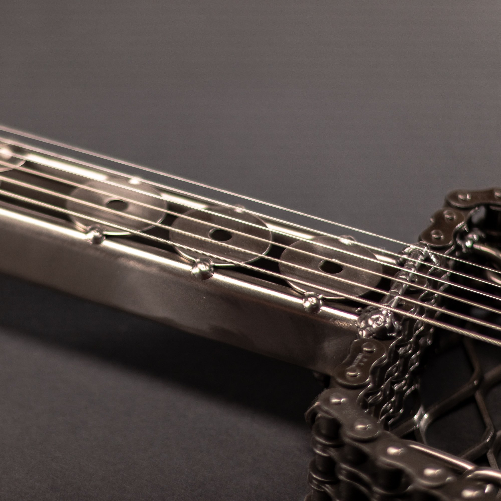 Handmade metal electric guitar sculpture, life-size, crafted from scrap metal with a clear finish.
