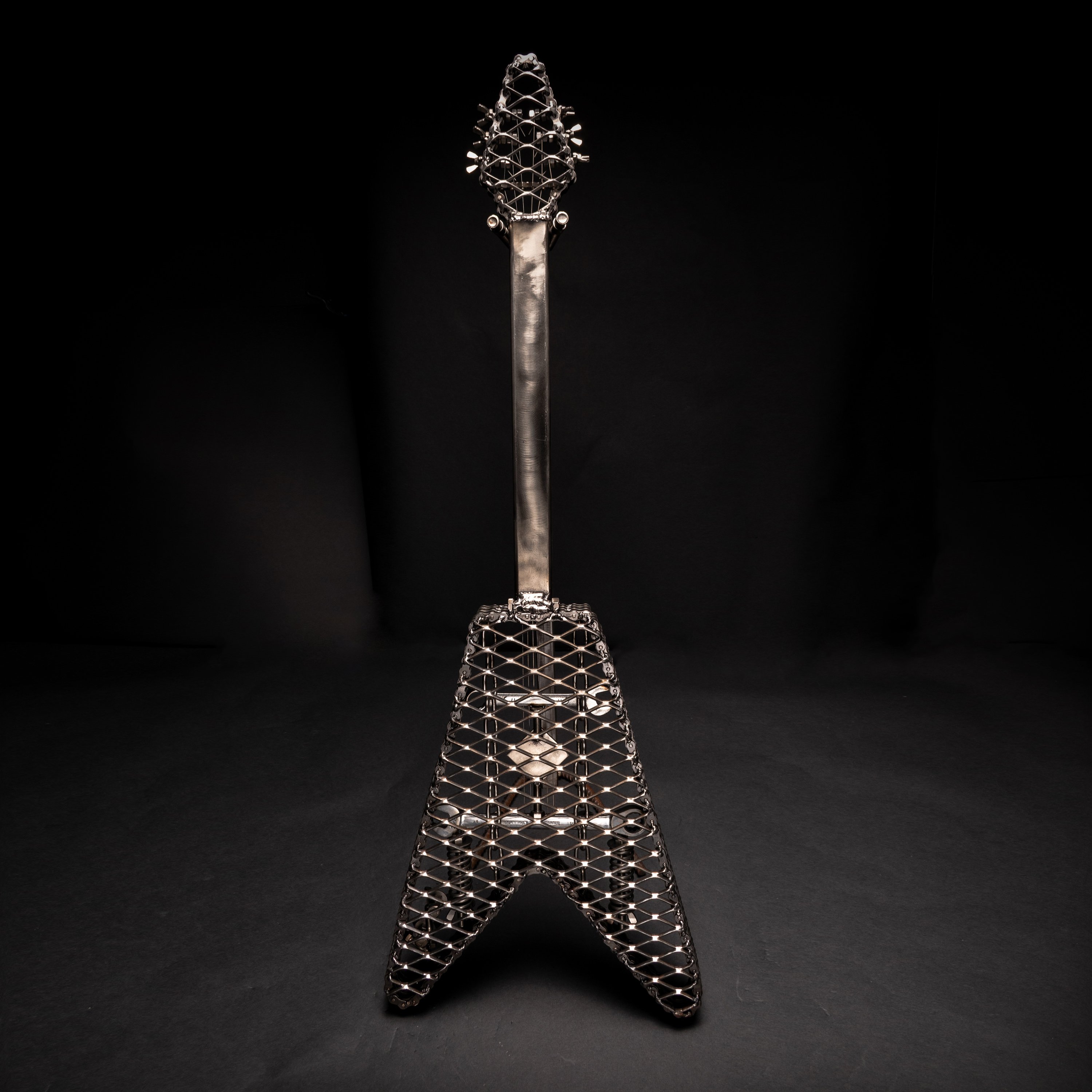 Handmade metal electric guitar sculpture, life-size, crafted from scrap metal with a clear finish.