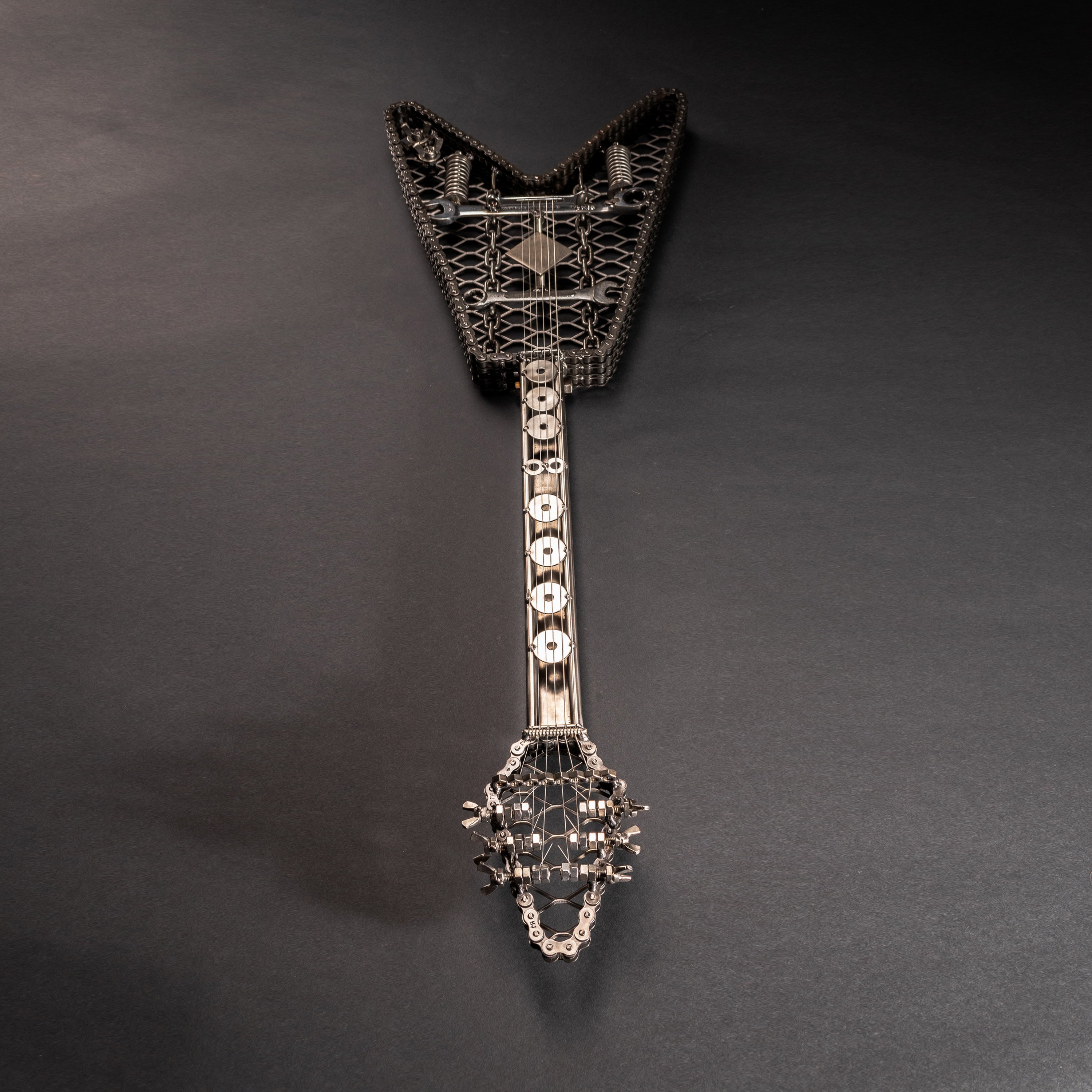 Handmade metal electric guitar sculpture, life-size, crafted from scrap metal with a clear finish.