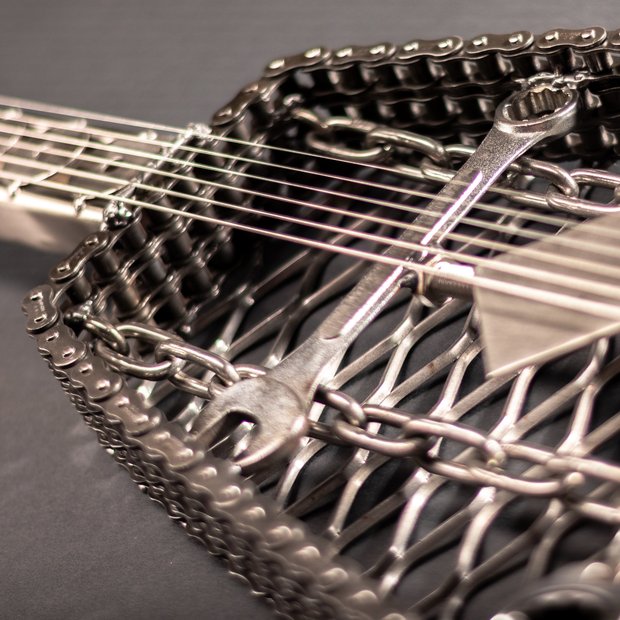 Handmade metal electric guitar sculpture, life-size, crafted from scrap metal with a clear finish.