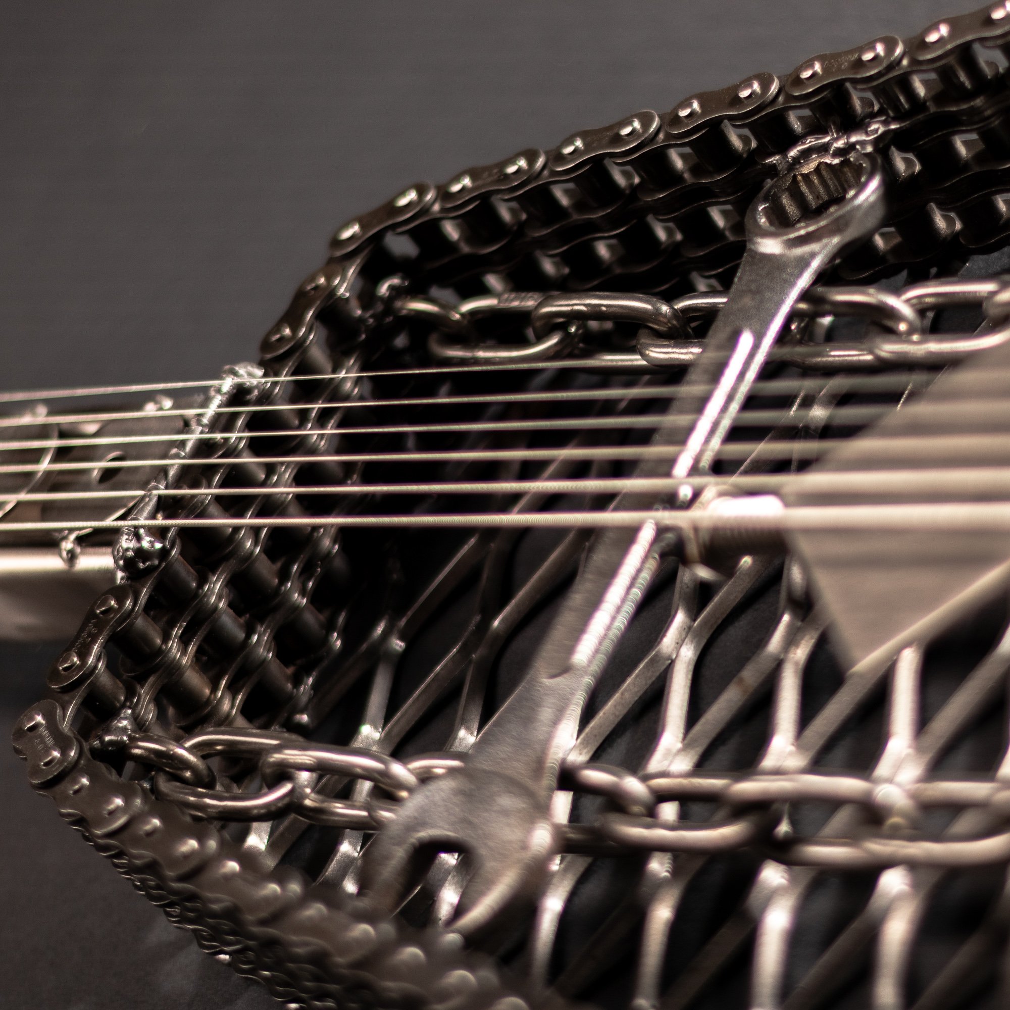 Handmade metal electric guitar sculpture, life-size, crafted from scrap metal with a clear finish.