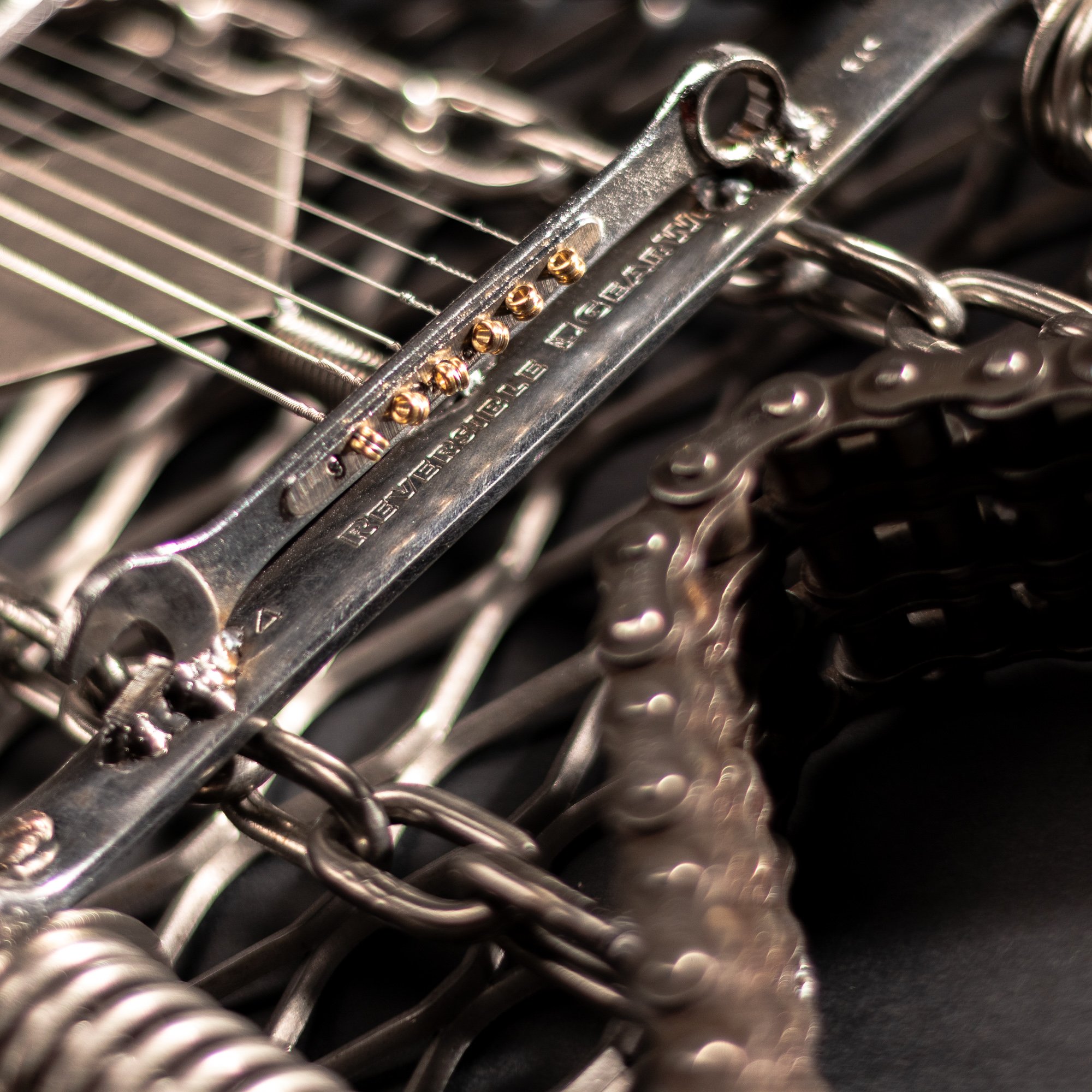 Handmade metal electric guitar sculpture, life-size, crafted from scrap metal with a clear finish.