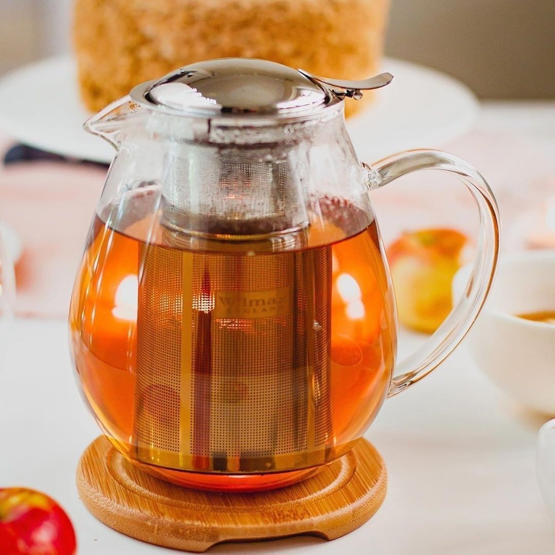 Elegant Thermo Glass Teapot made of borosilicate glass with a bamboo lid and stainless steel infuser, perfect for hot and cold beverages.