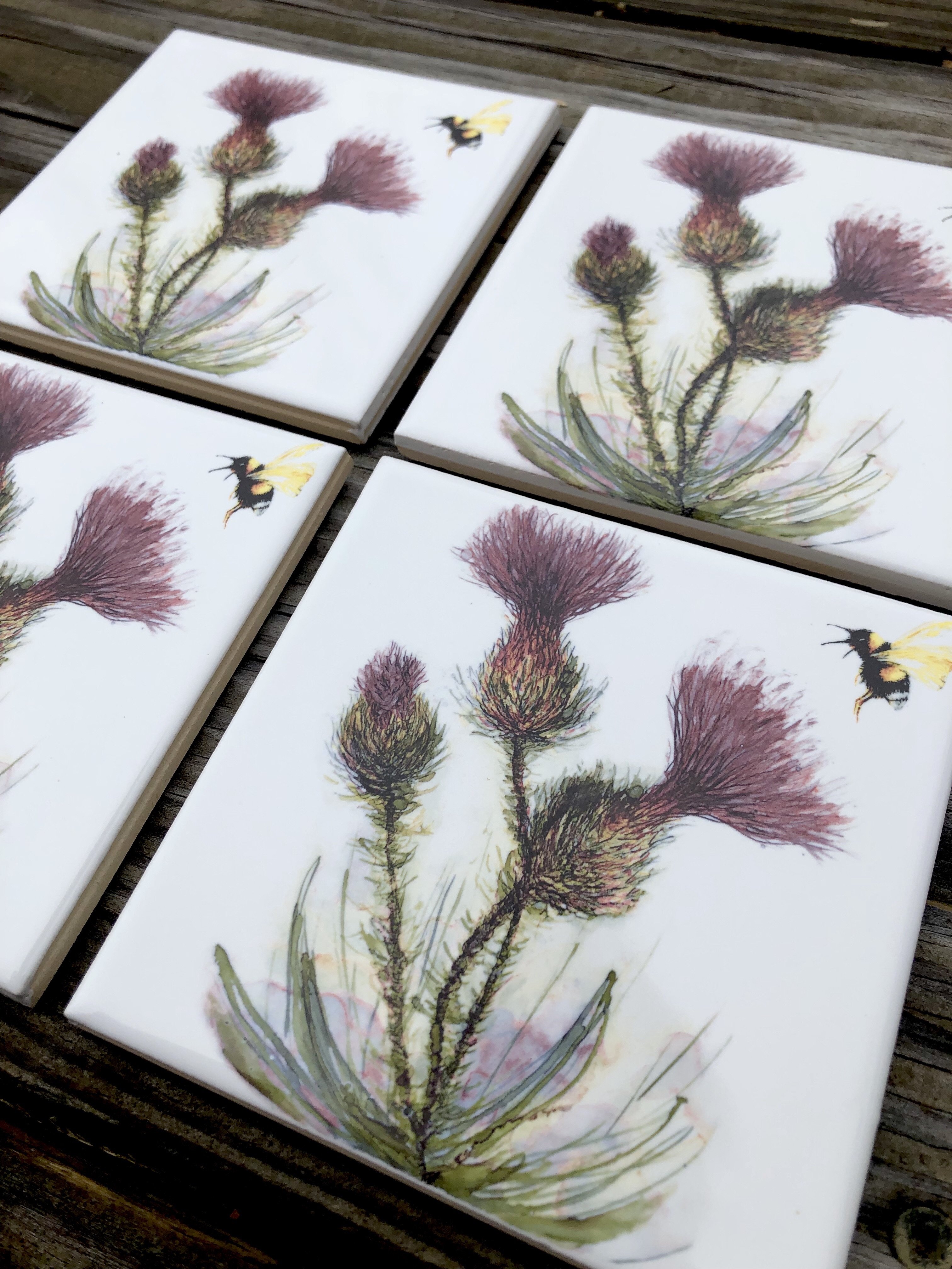 Thistle and Honeybee Ceramic Tiles showcasing intricate designs, perfect for indoor and outdoor decor.