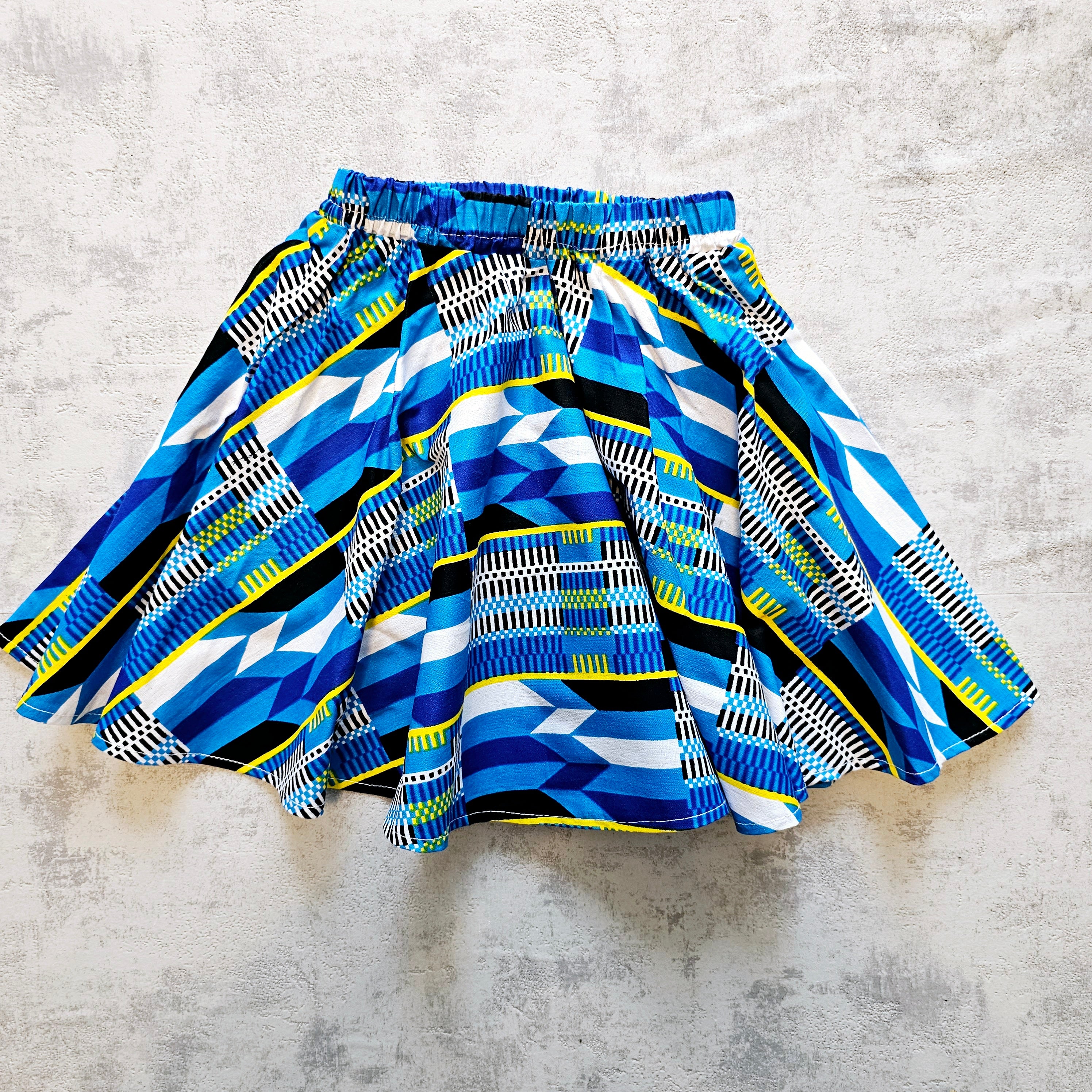 A vibrant Toddler Circle Skirt made from Ankara fabric, featuring a colorful design and an elastic waist, perfect for playful little girls.