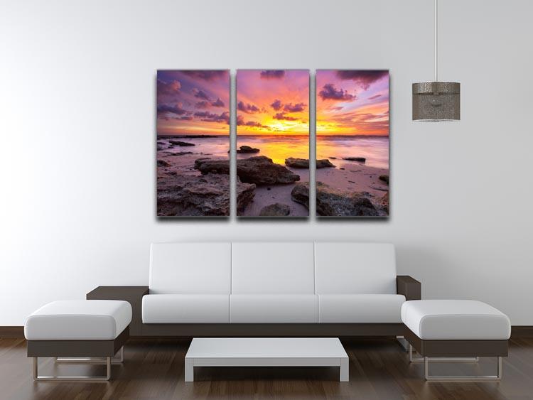A stunning 3-panel canvas print depicting a tropical beach at sunset, showcasing vibrant colors and serene scenery.