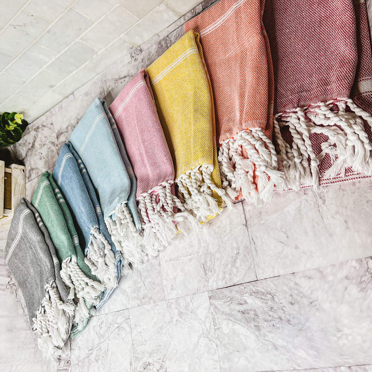 Luxurious oversized Turkish hand towel with bamboo tassels, showcasing vibrant colors and elegant design.