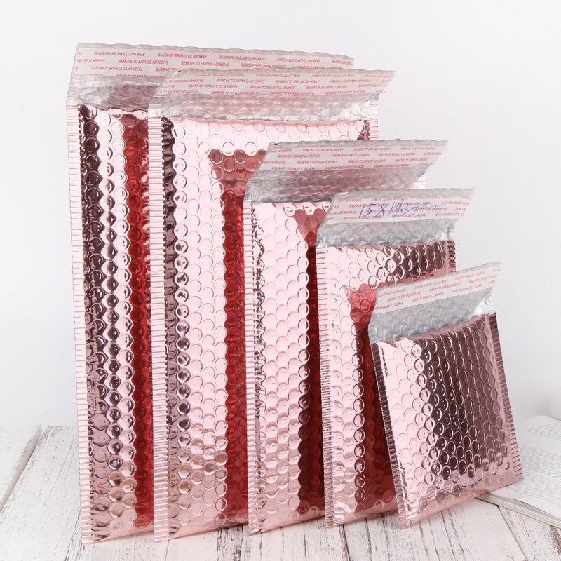Pack of 10 metallic padded bubble mailers in rose gold, rose pink, and holographic colors, showcasing their durable design and self-sealing adhesive strip.