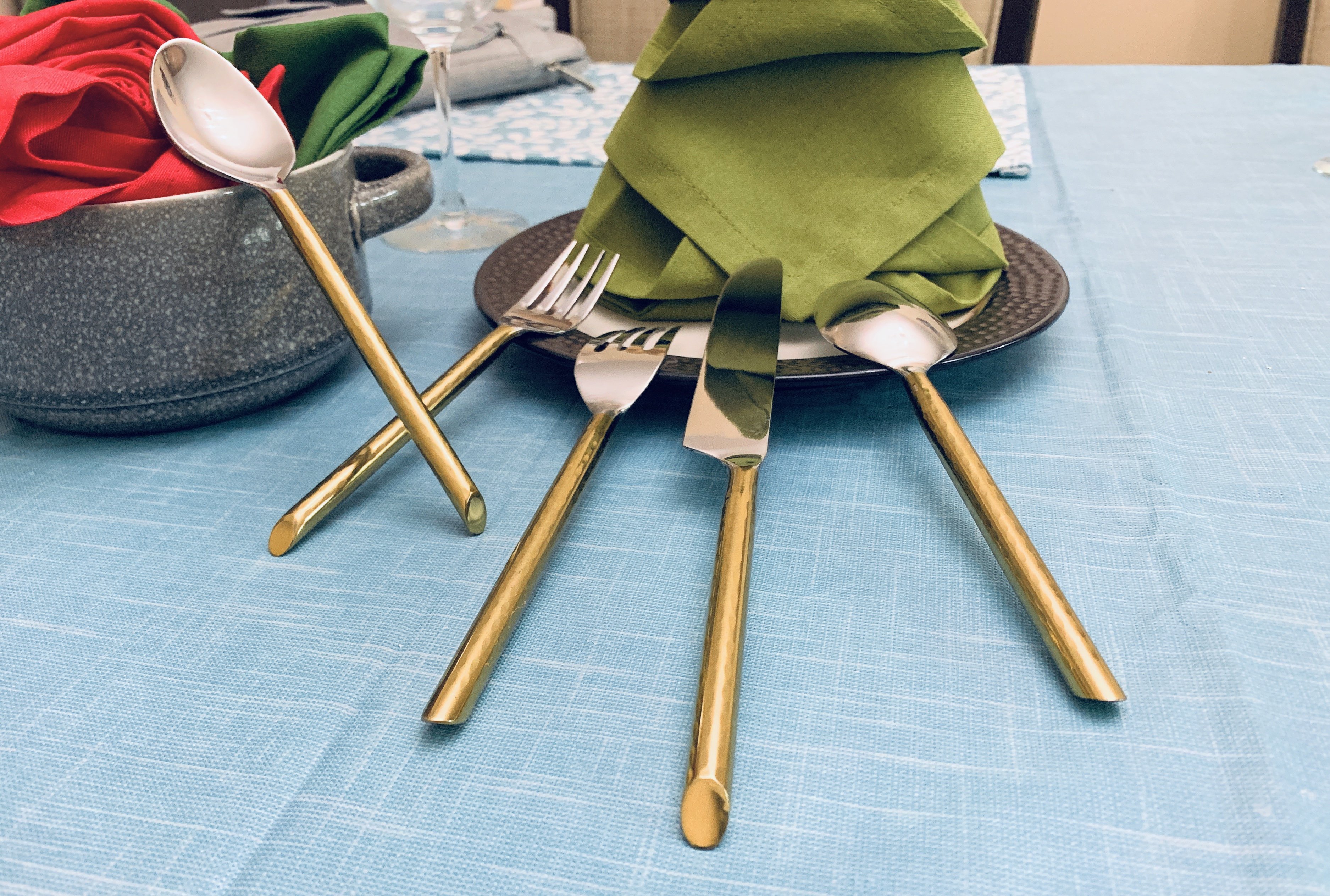 Vibhsa Stainless Steel Gold Flatware set of 20 pieces displayed elegantly on a dining table, showcasing its luxurious design and polished finish.