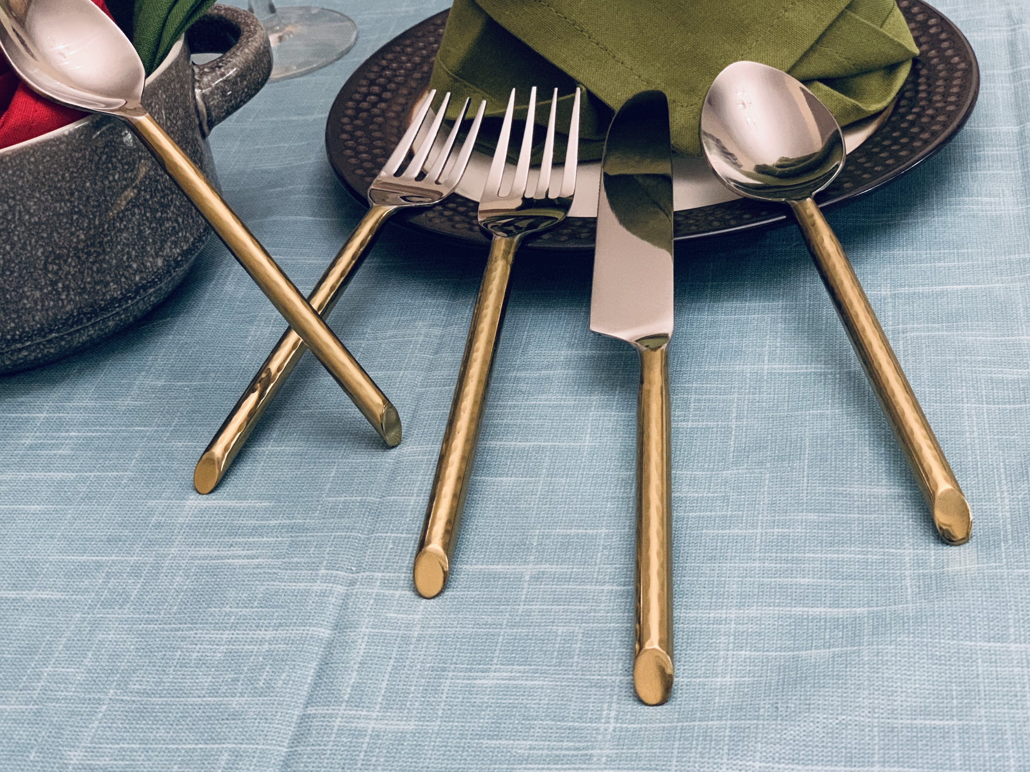 Vibhsa Stainless Steel Gold Flatware set of 20 pieces displayed elegantly on a dining table, showcasing its luxurious design and polished finish.