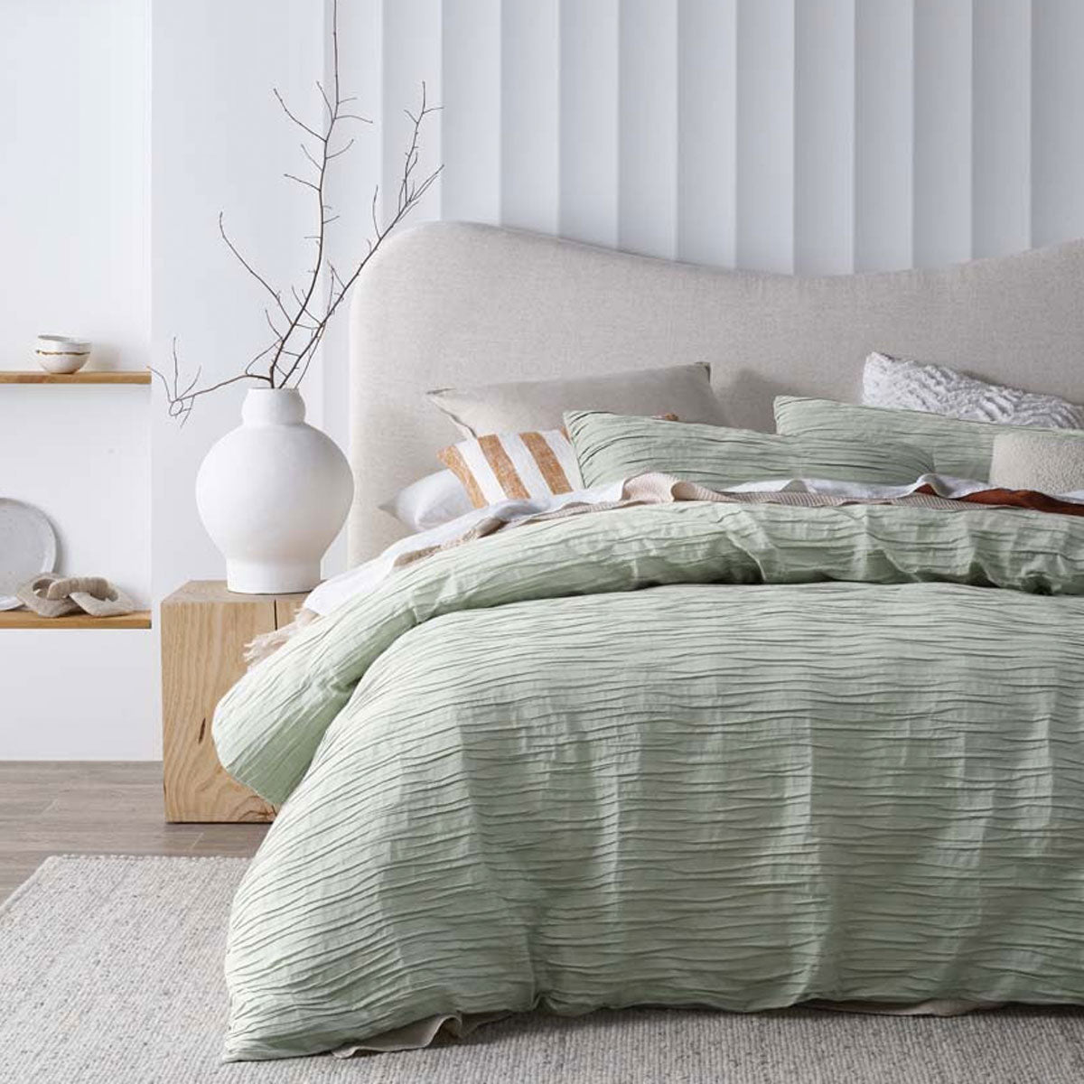 Malvern Sage Cotton Quilt Cover Set featuring horizontal pleats, perfect for a queen-sized bed, showcasing a chic and minimalist design.